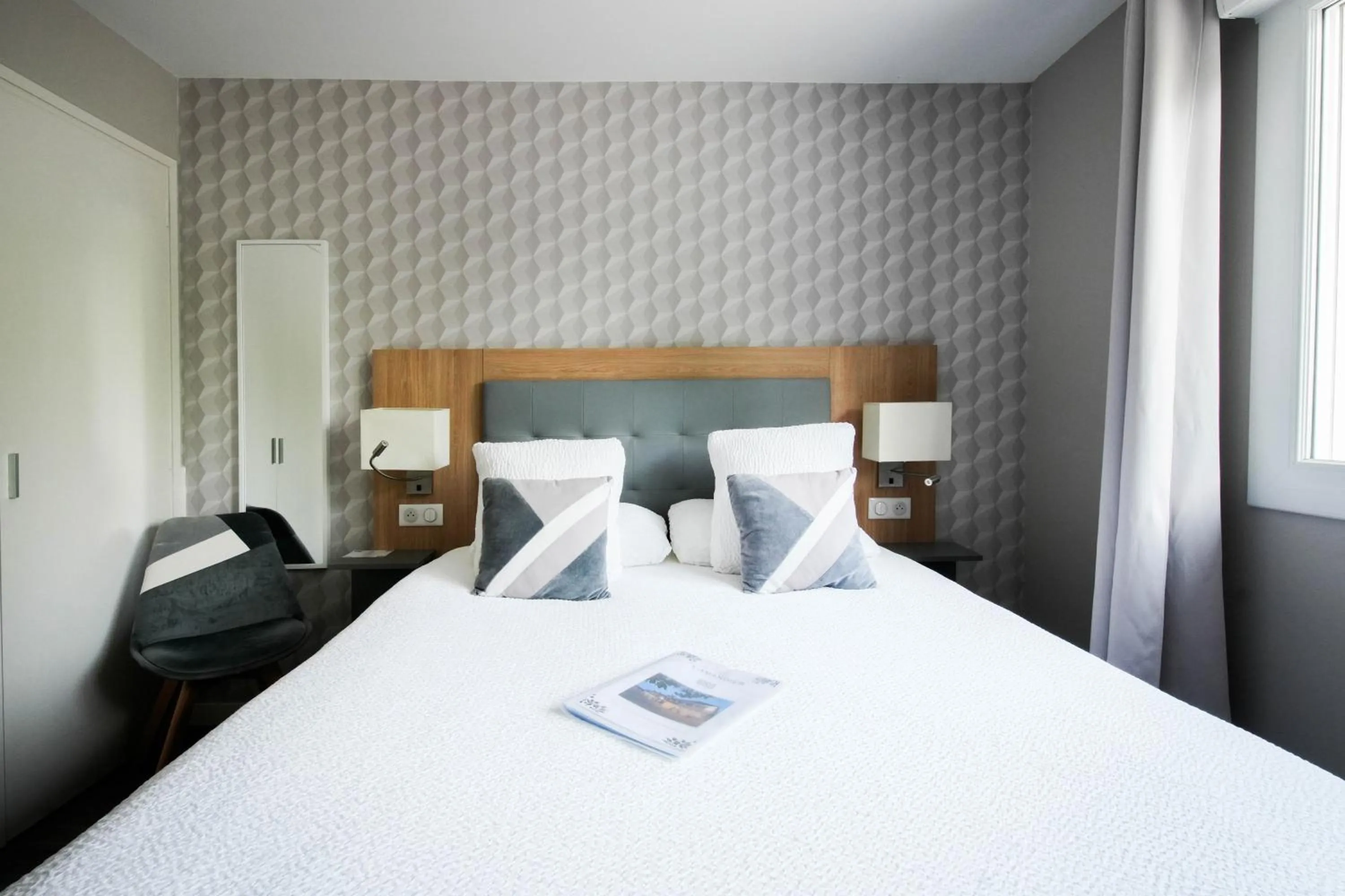 Bed in Logis Hôtel l'Amandier