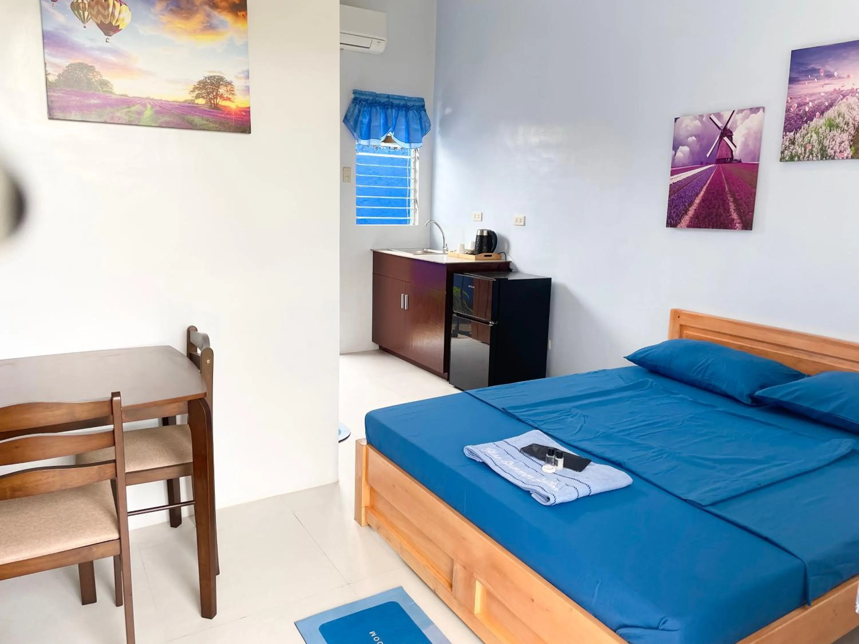 Bed in Blue Summer Suites & Restaurant