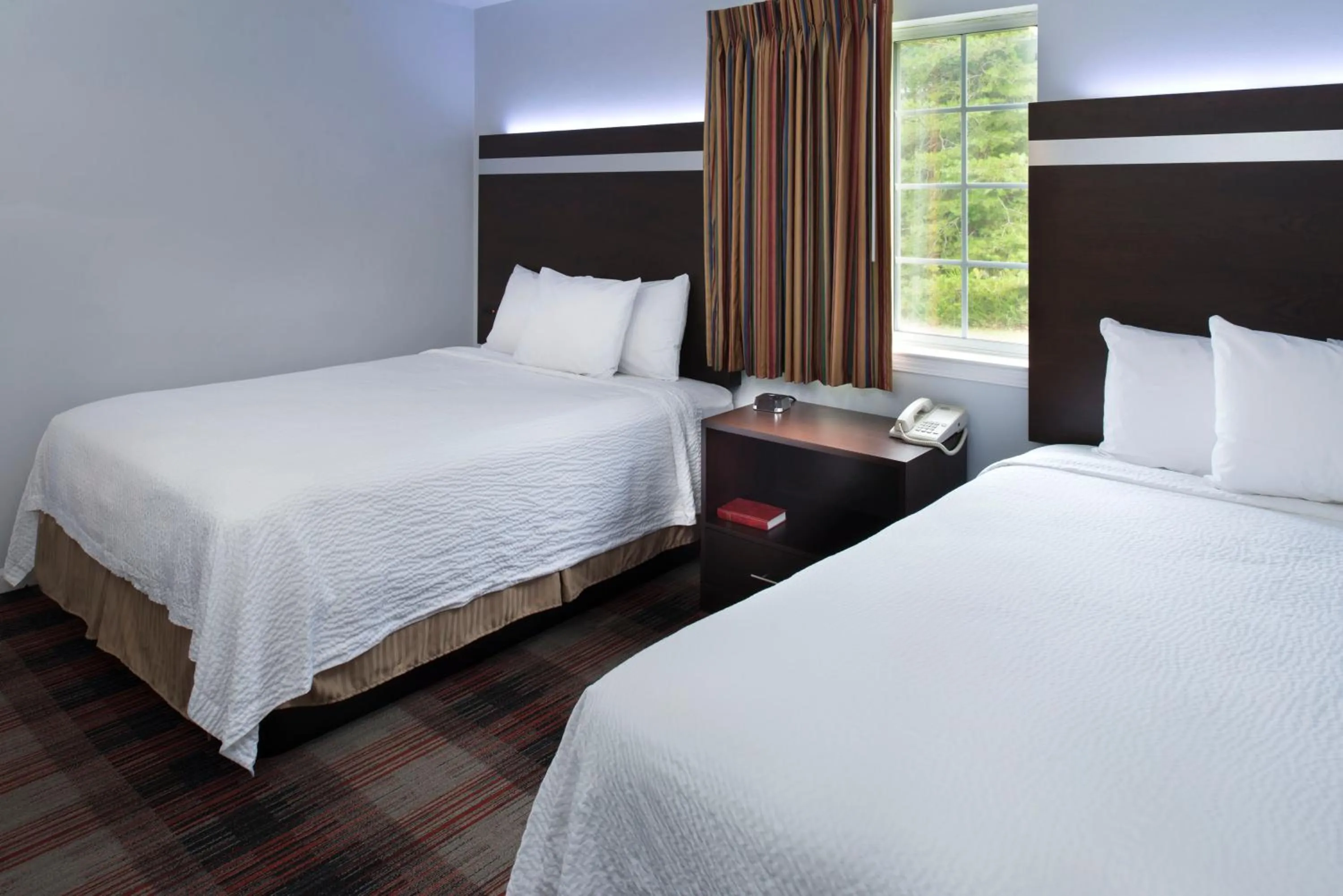 Bed in Luxbury Inn & Suites