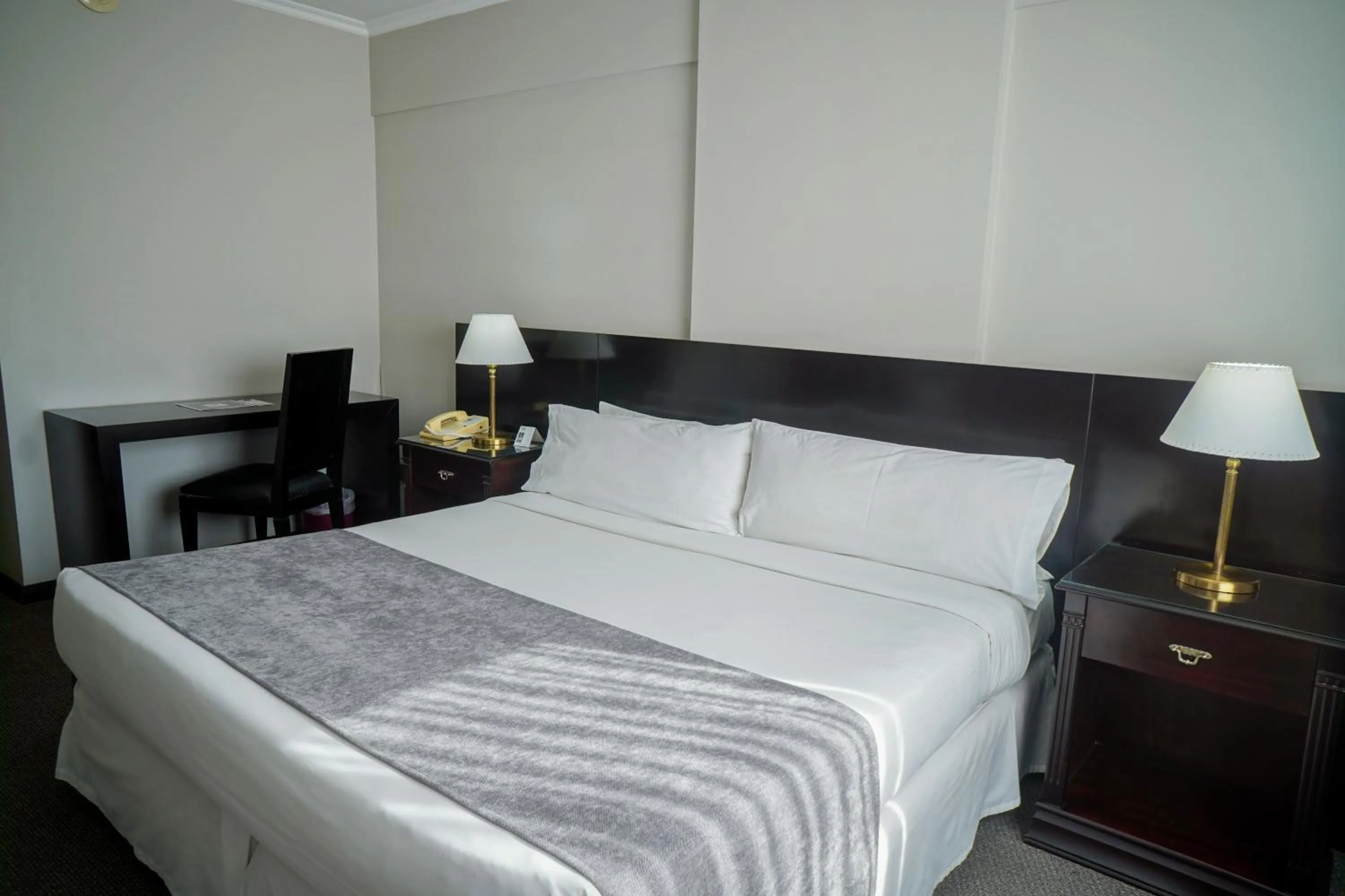 Bed in Plaza Real Suites Hotel