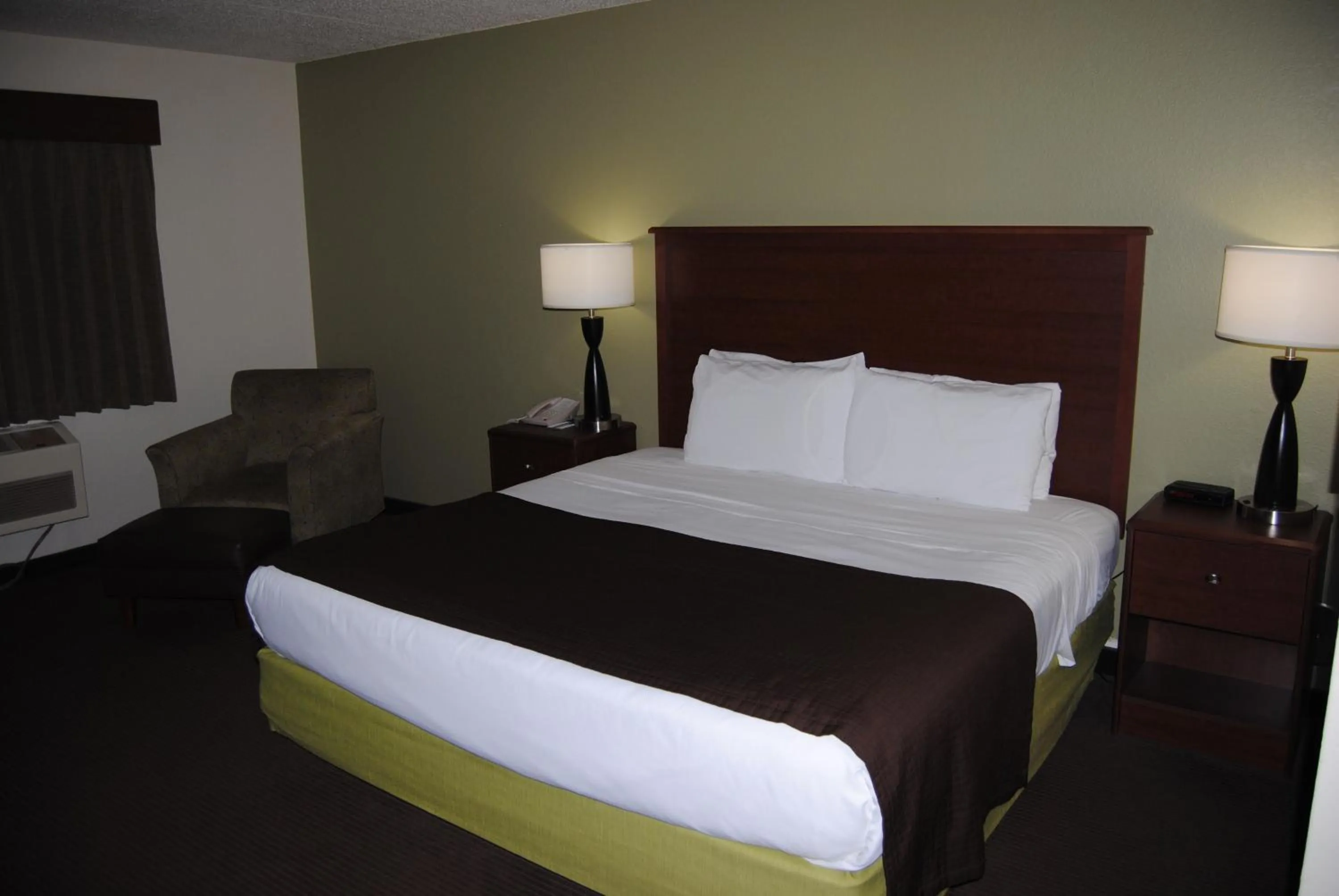 Bed in AmericInn by Wyndham Grand Rapids