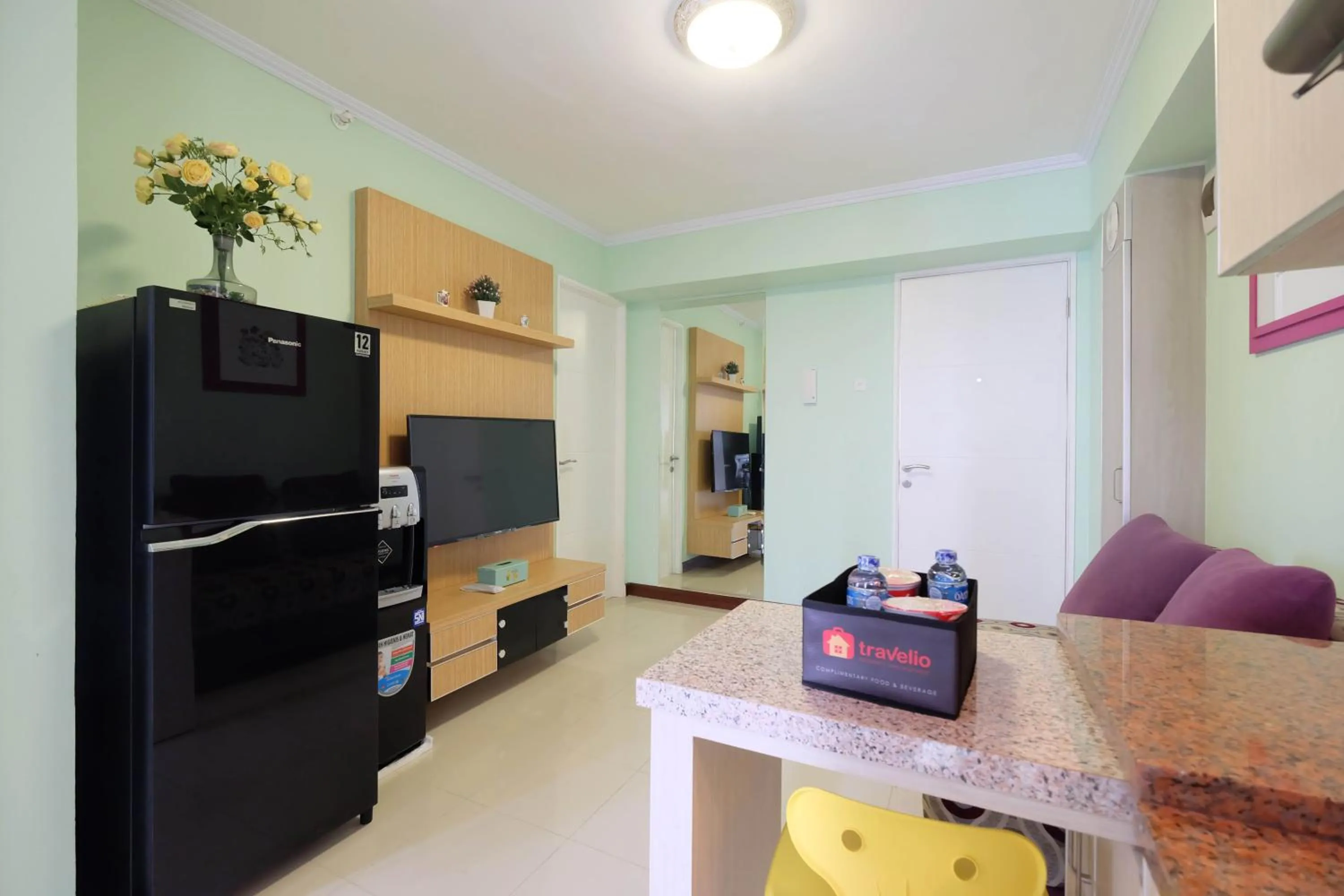 Living room in Cozy 2BR Bassura City Apartment By Travelio