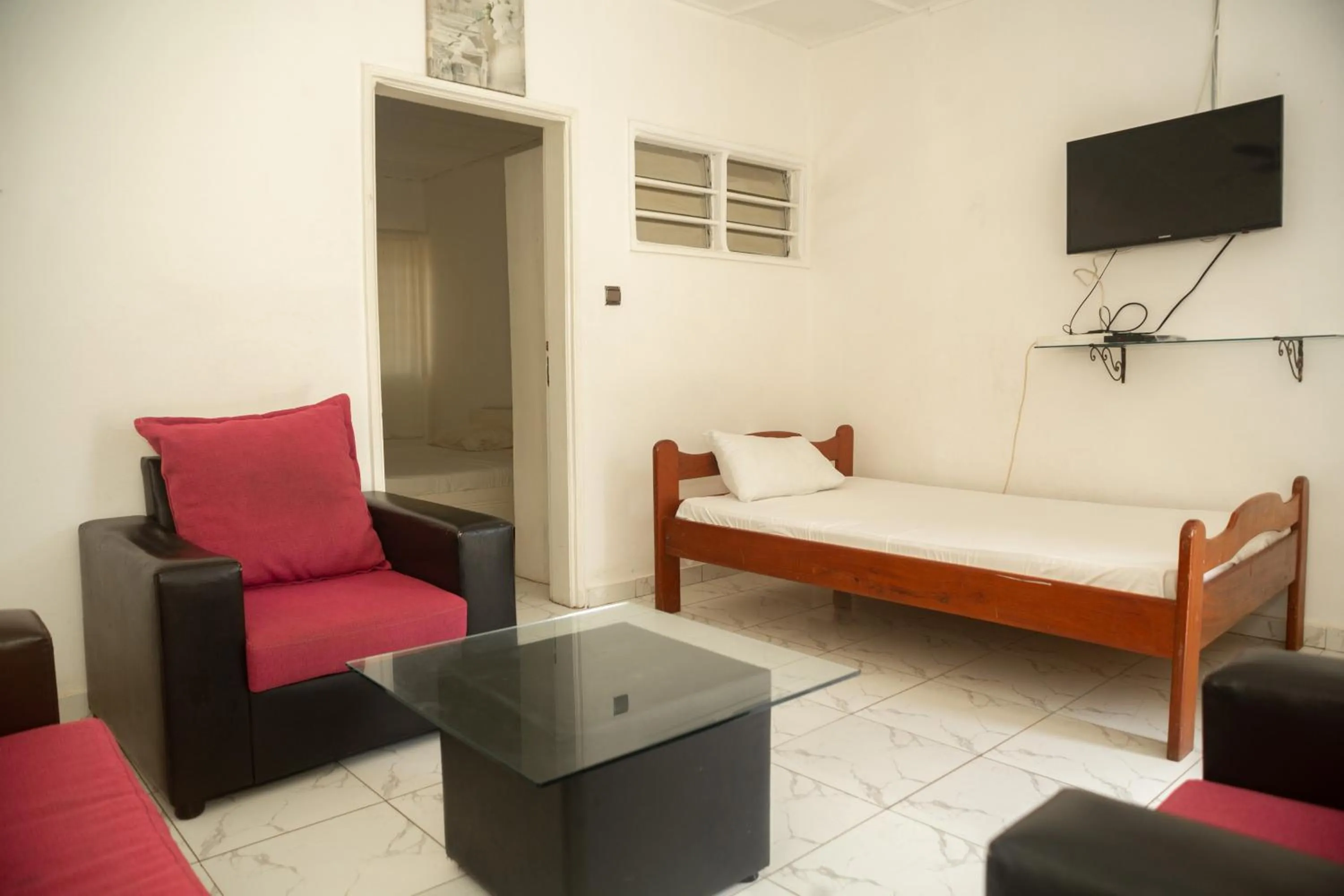 Communal lounge/ TV room, Bed in Tahiti Hotel