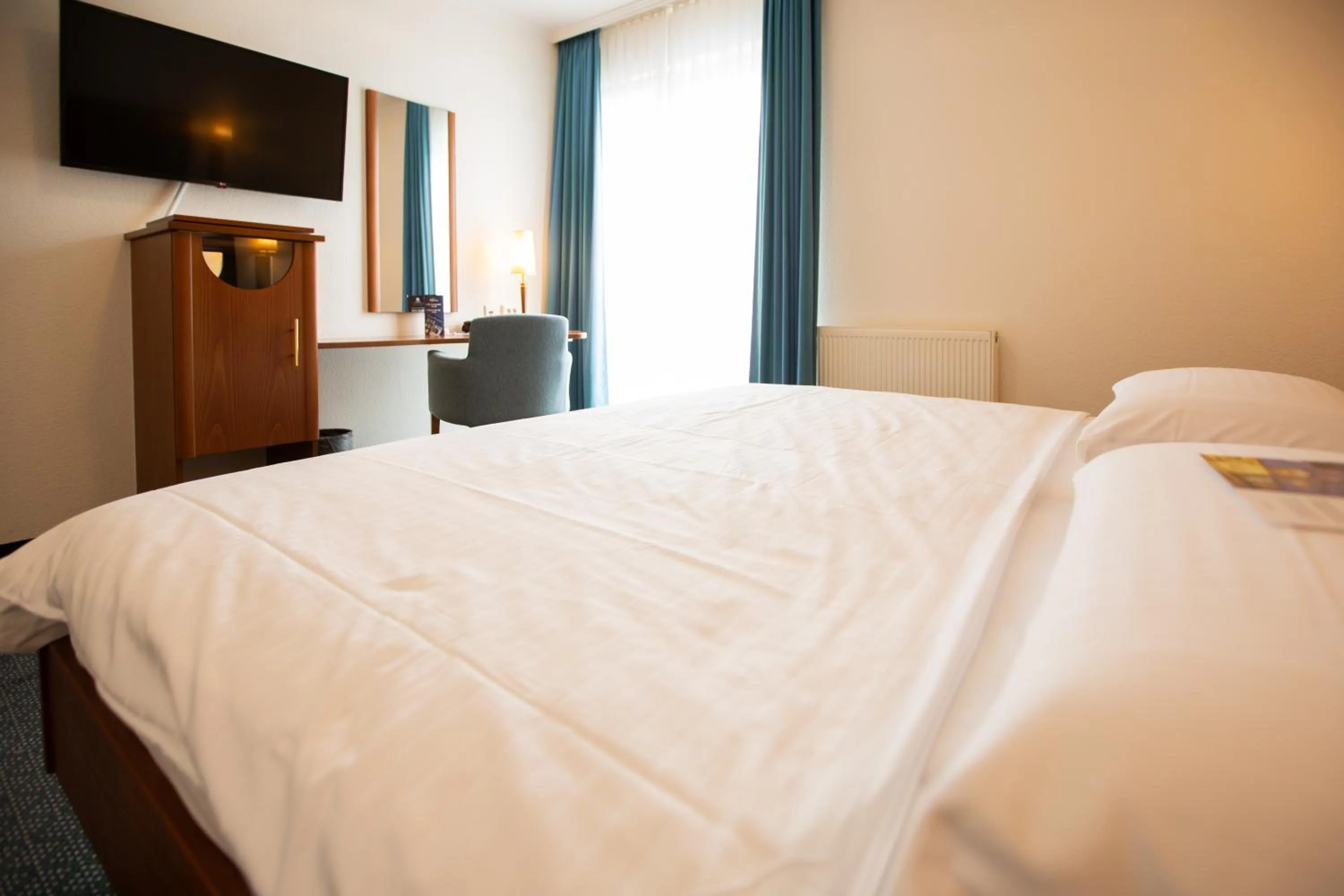 Communal lounge/ TV room, Bed in Ringhotel Appelbaum Gütersloh