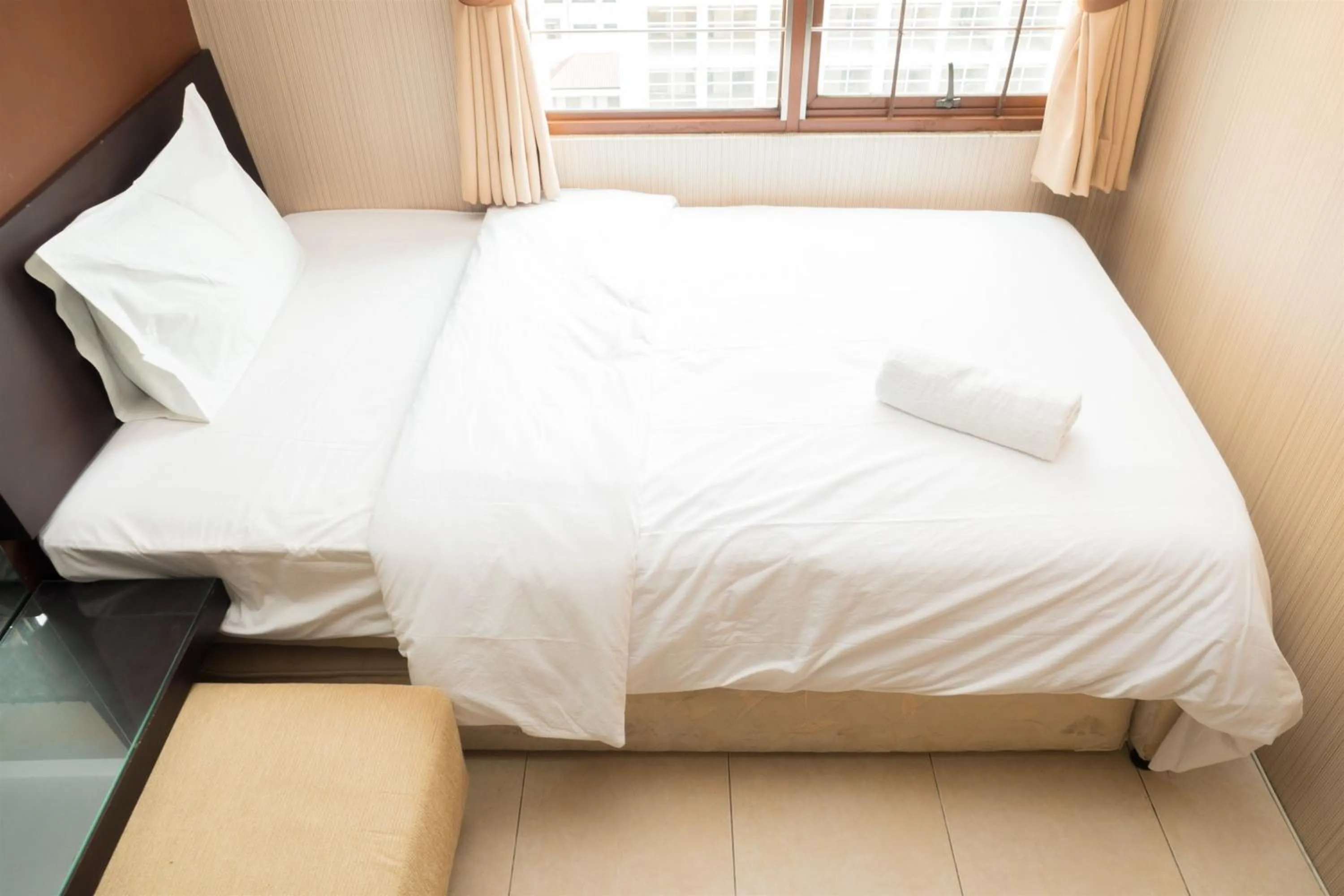 Bed in Antique 3BR at Grand Setiabudi Apartment By Travelio