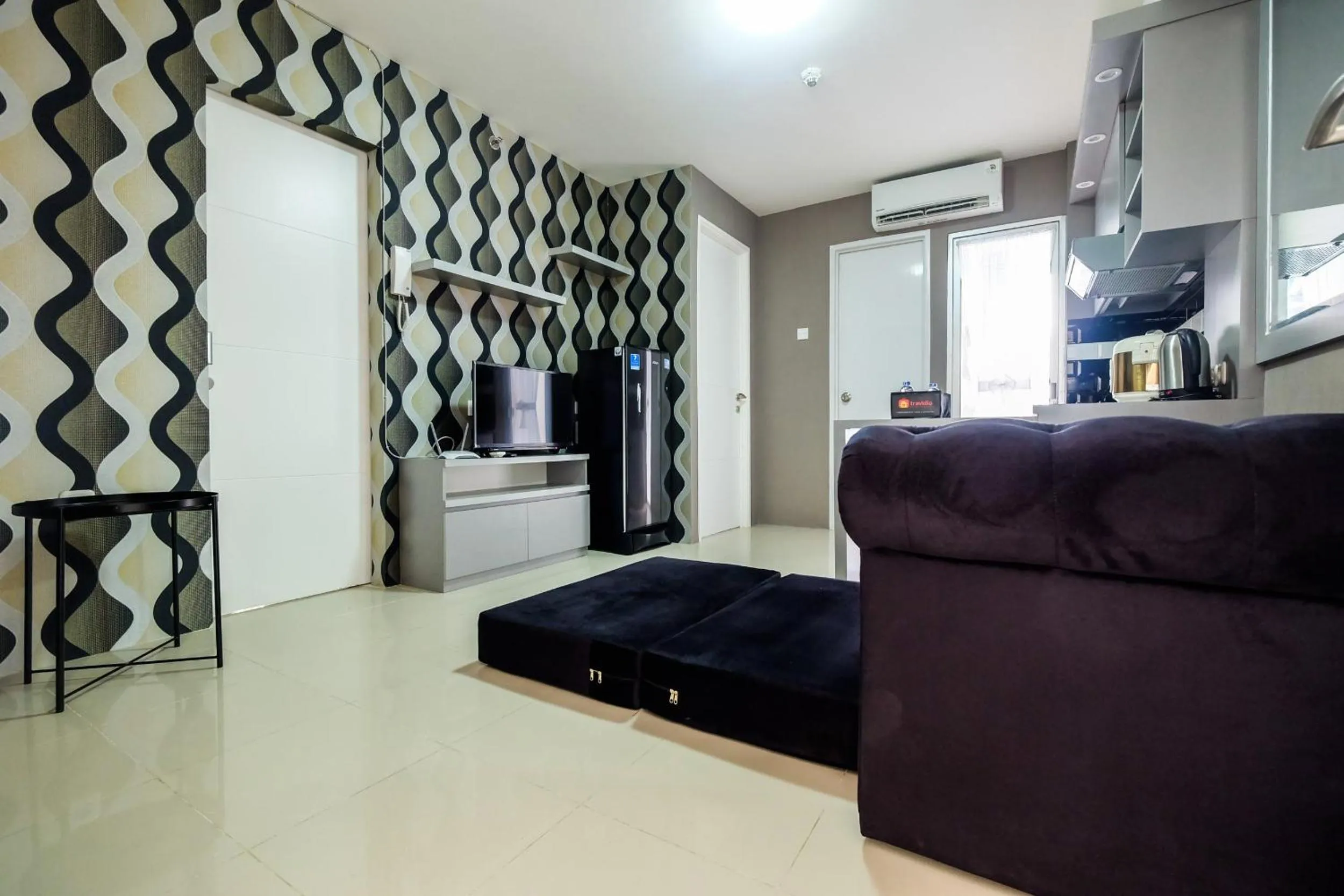 Living room in Modern and Comfort 2BR Bassura City Apartment By Travelio