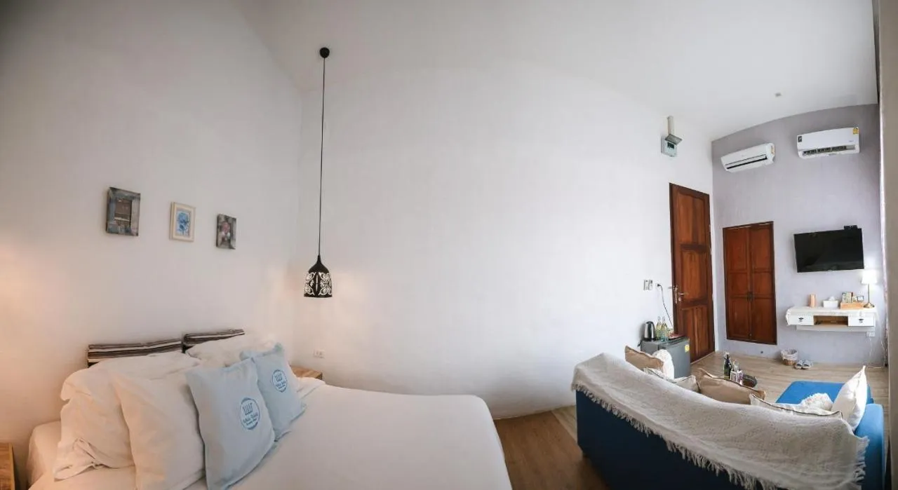 Bed in White Wall Riverfront Hotel