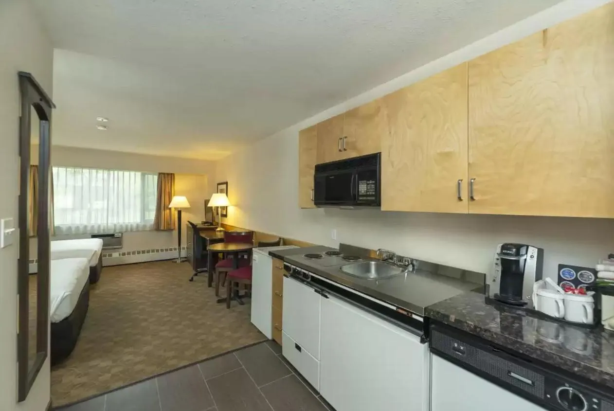 Kitchen or kitchenette, Bed in Prestige Riverside Lodge Quesnel