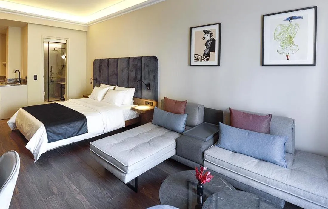 Seating area, Bed in Roomore Apartments