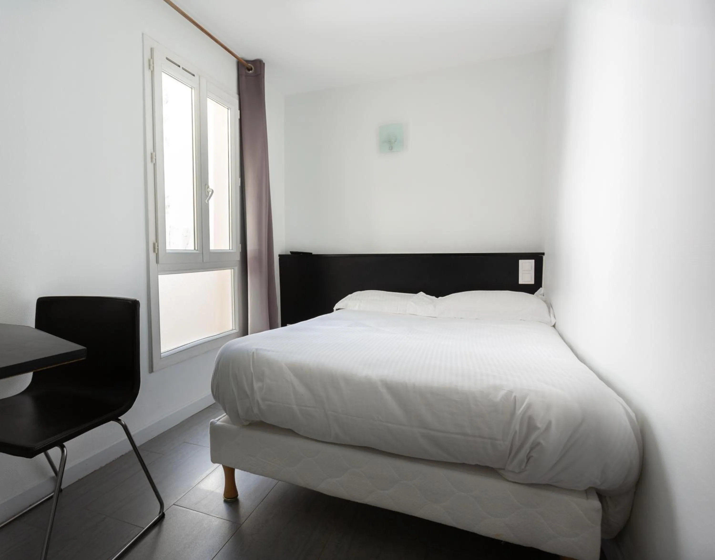 Bed in Hotel Mimosa Paris