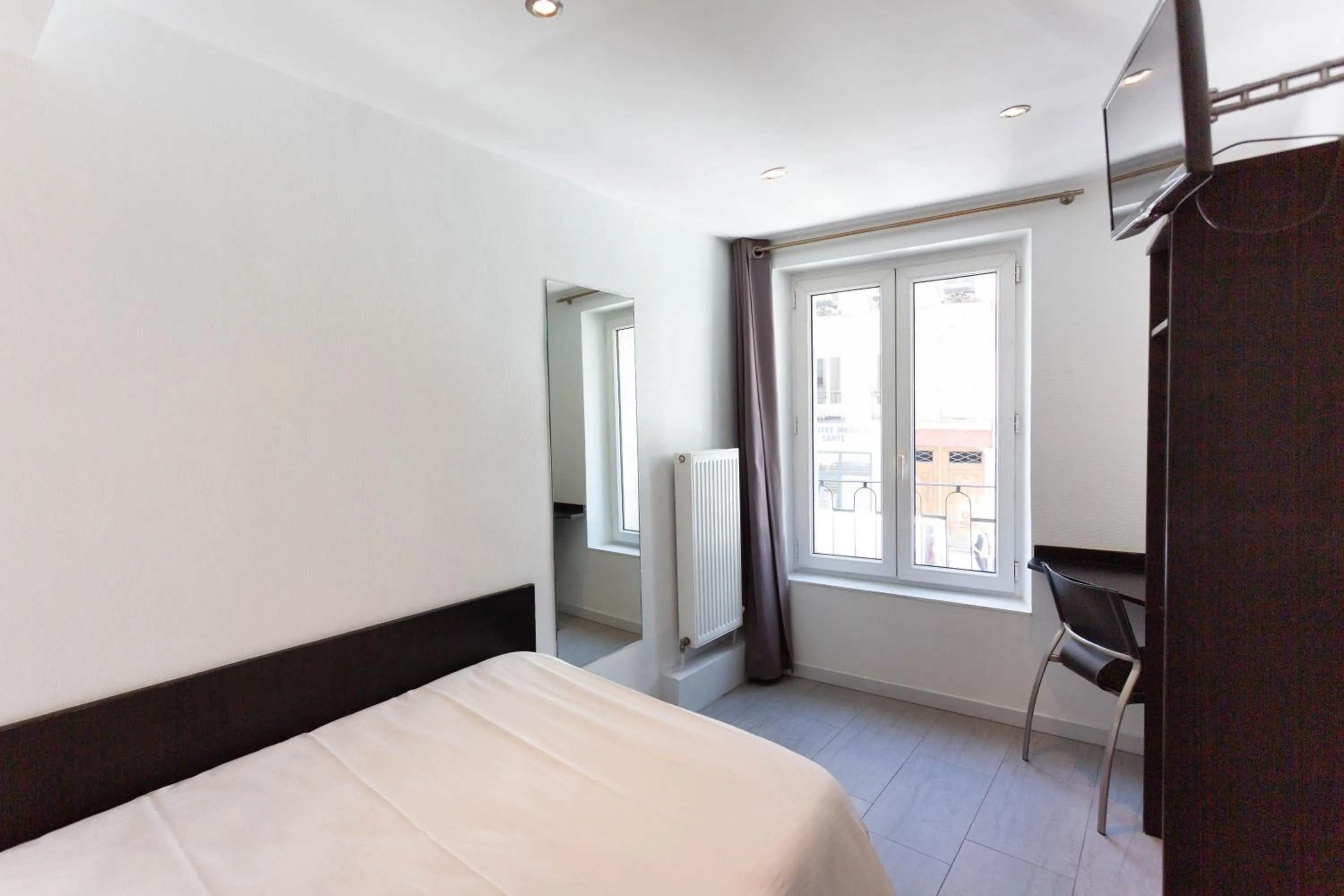 Bed in Hotel Mimosa Paris