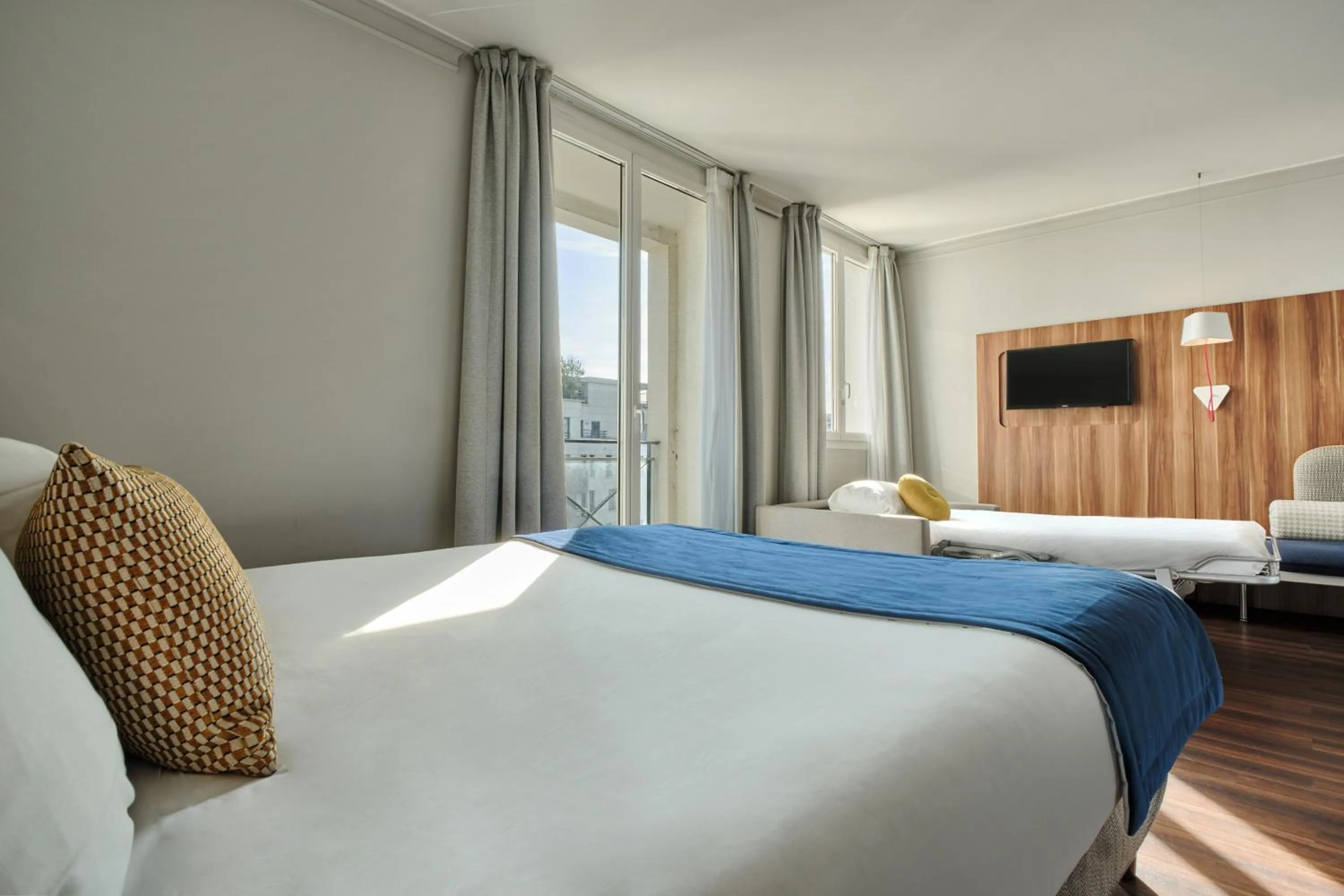 Bed in Hotel Atrium by Happyculture