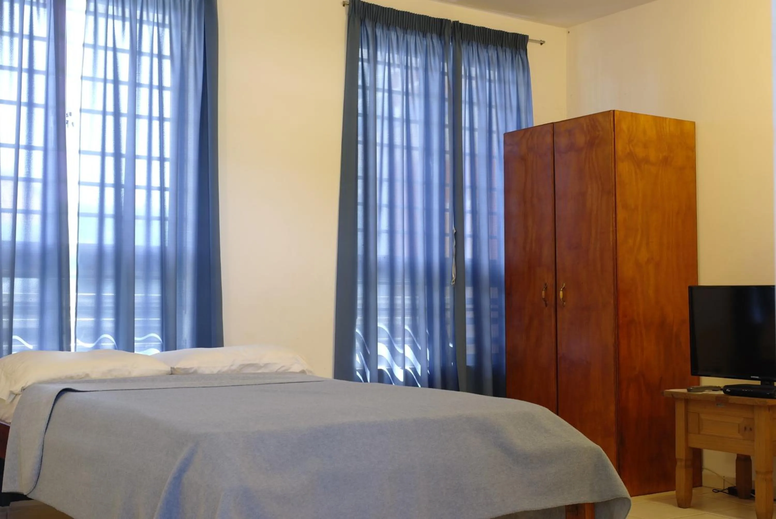 Bed in Orange Rembrandt Studio Apartments