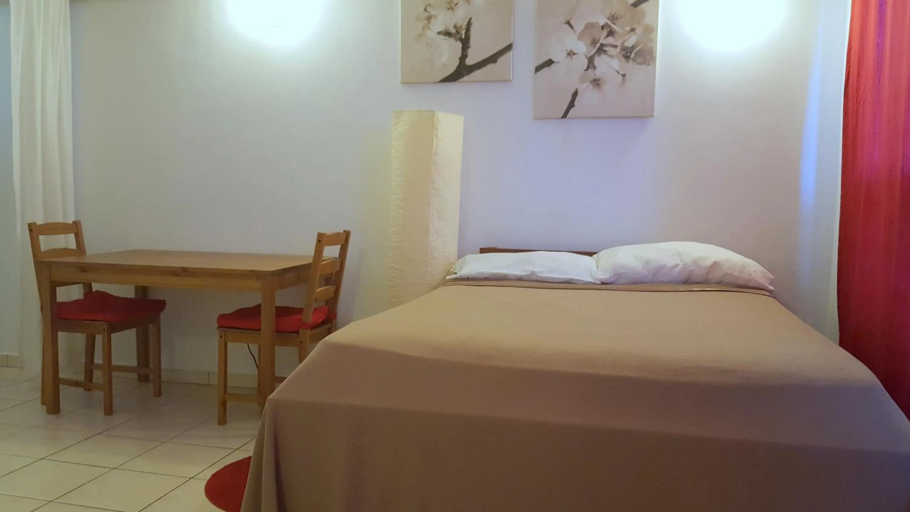 Bed in Orange Rembrandt Studio Apartments