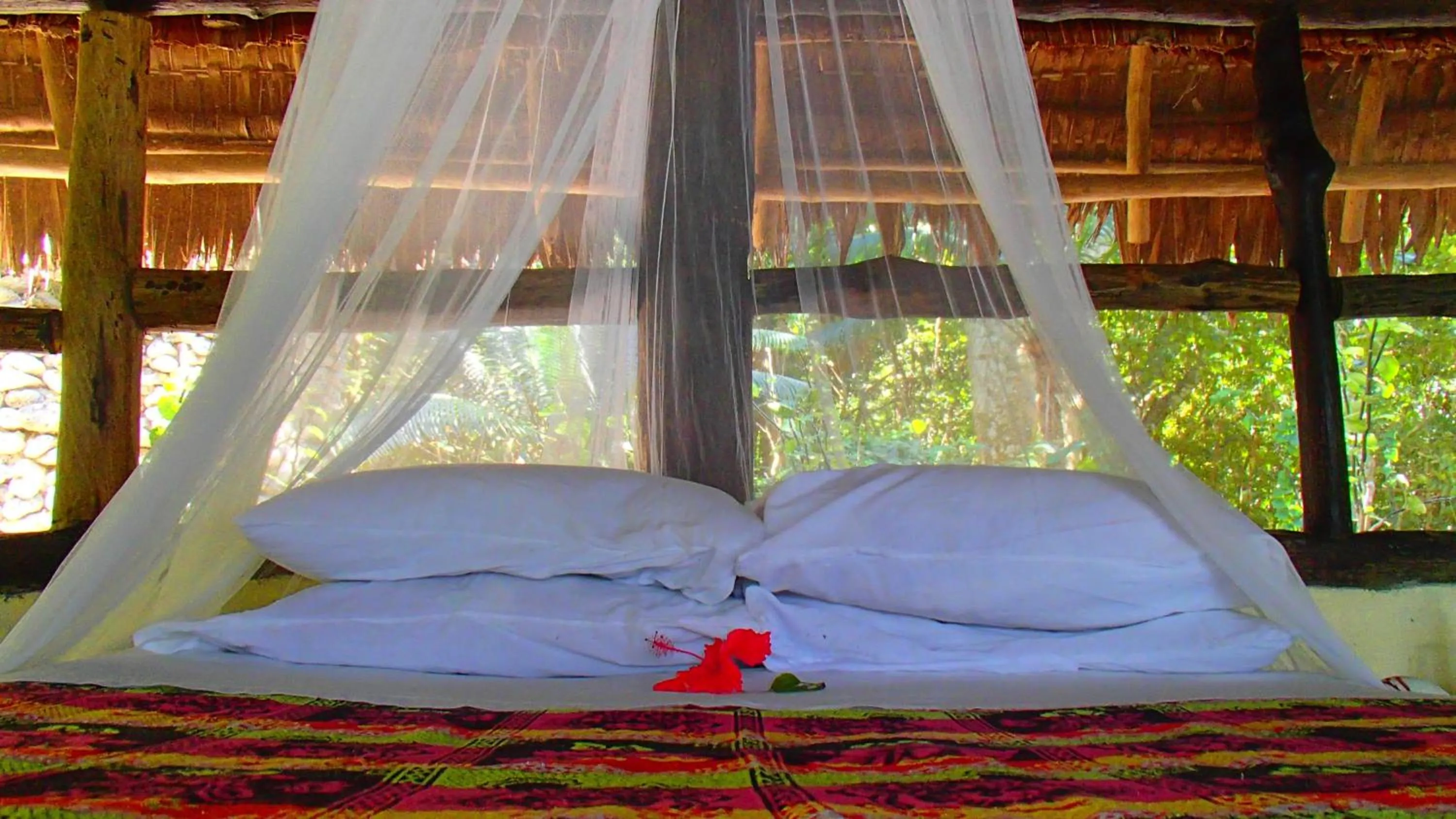 Bed in Tranquility Island Eco Dive Resort
