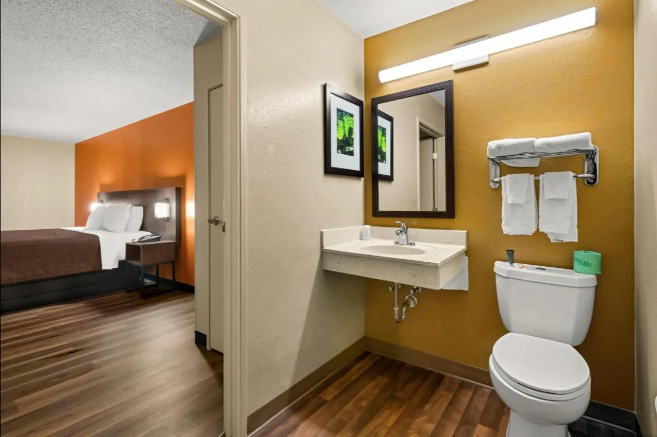 Toilet, Bed in Suburban Studios Winston-Salem near Hanes Mall