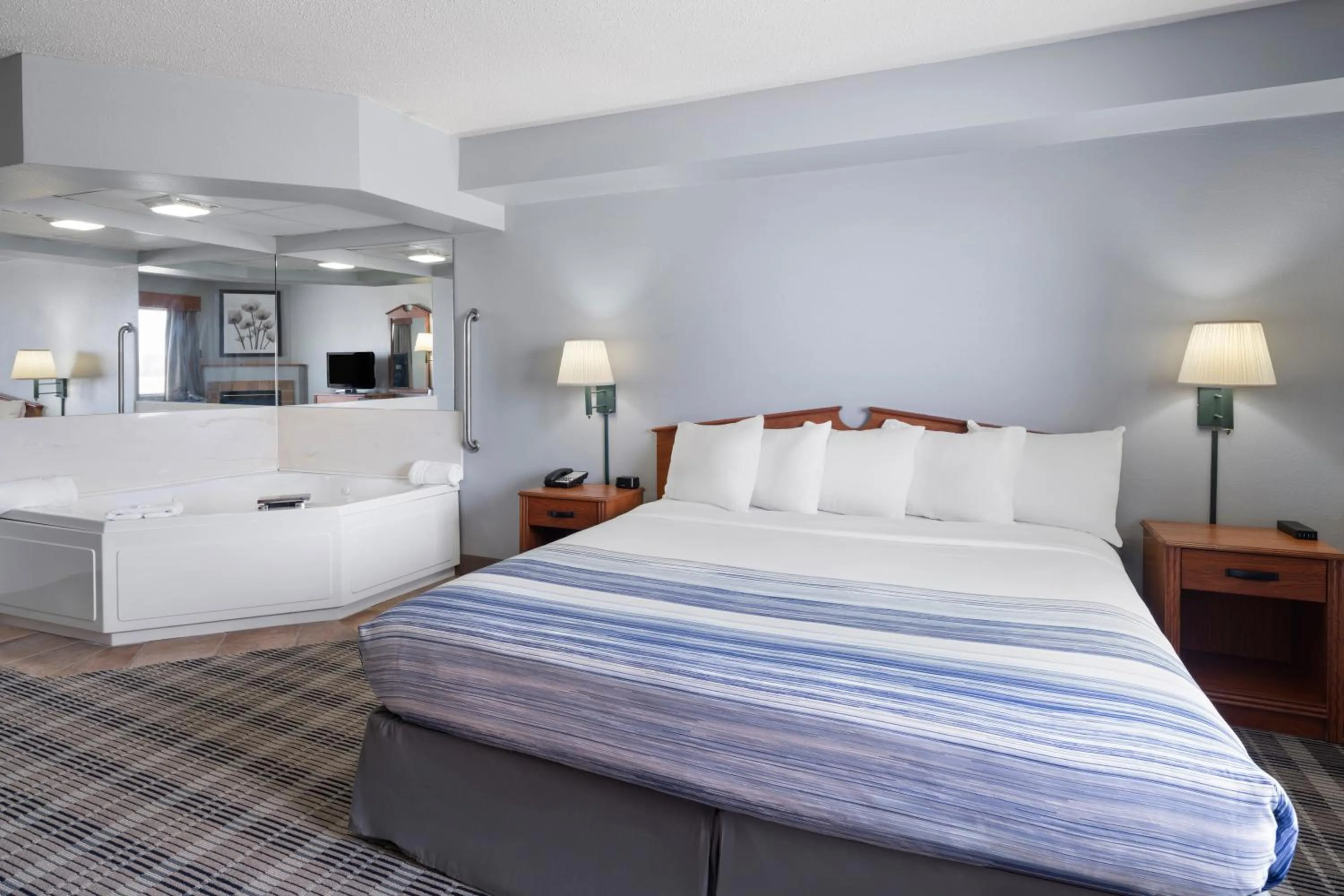 Bed in AmericInn by Wyndham Stuart