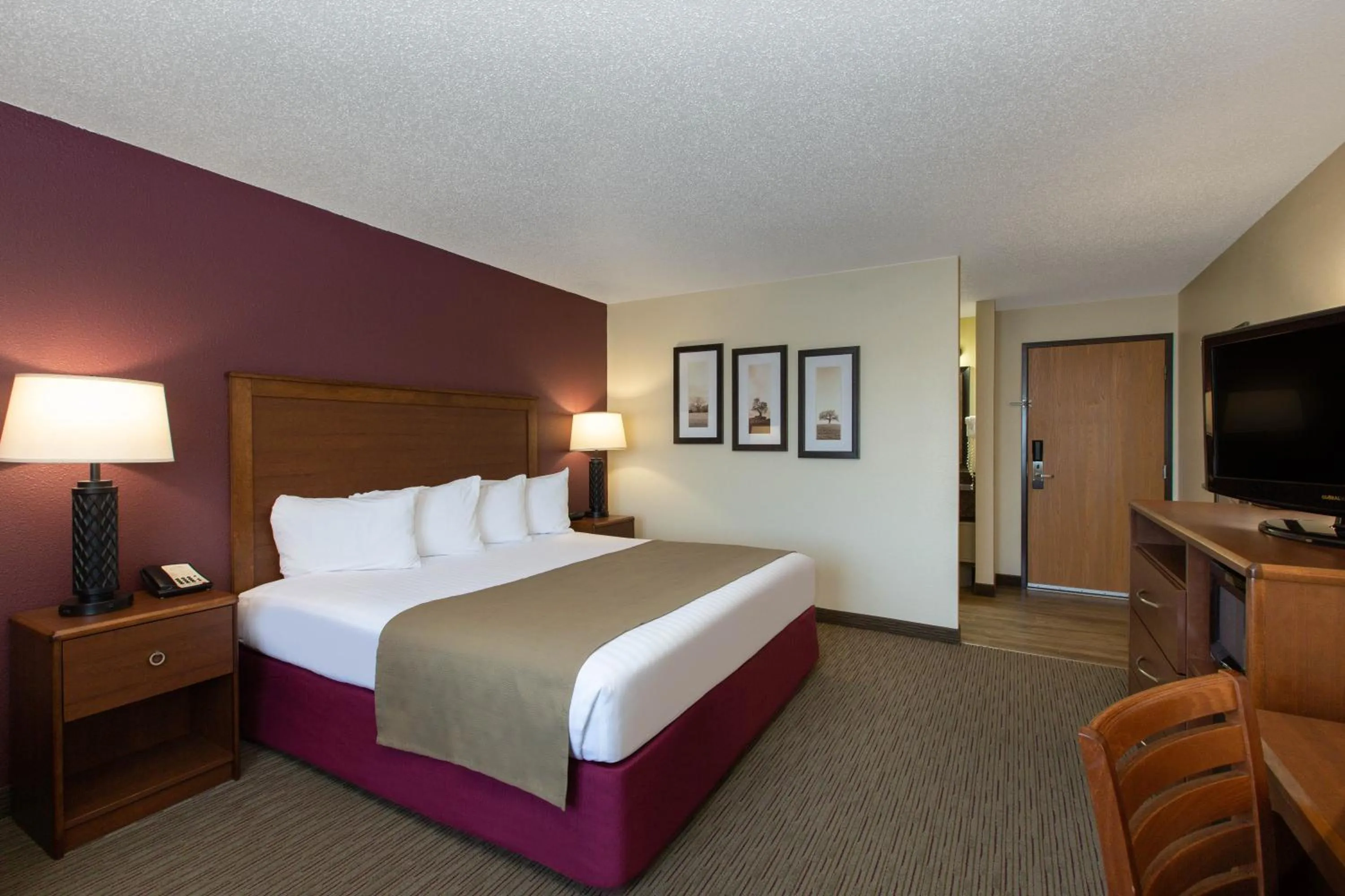 Bed in AmericInn by Wyndham Merrill