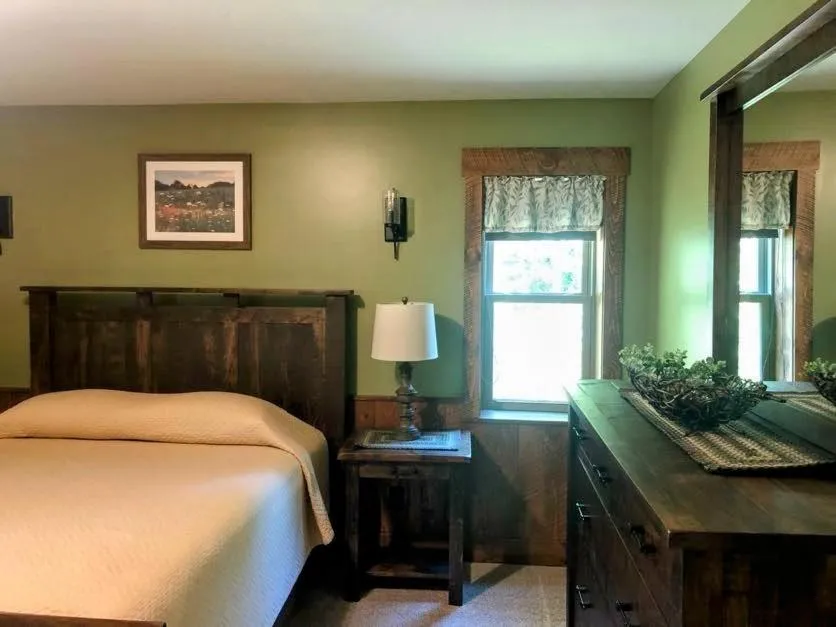 Bed in Sojourner's Lodge & Log Cabin Suites
