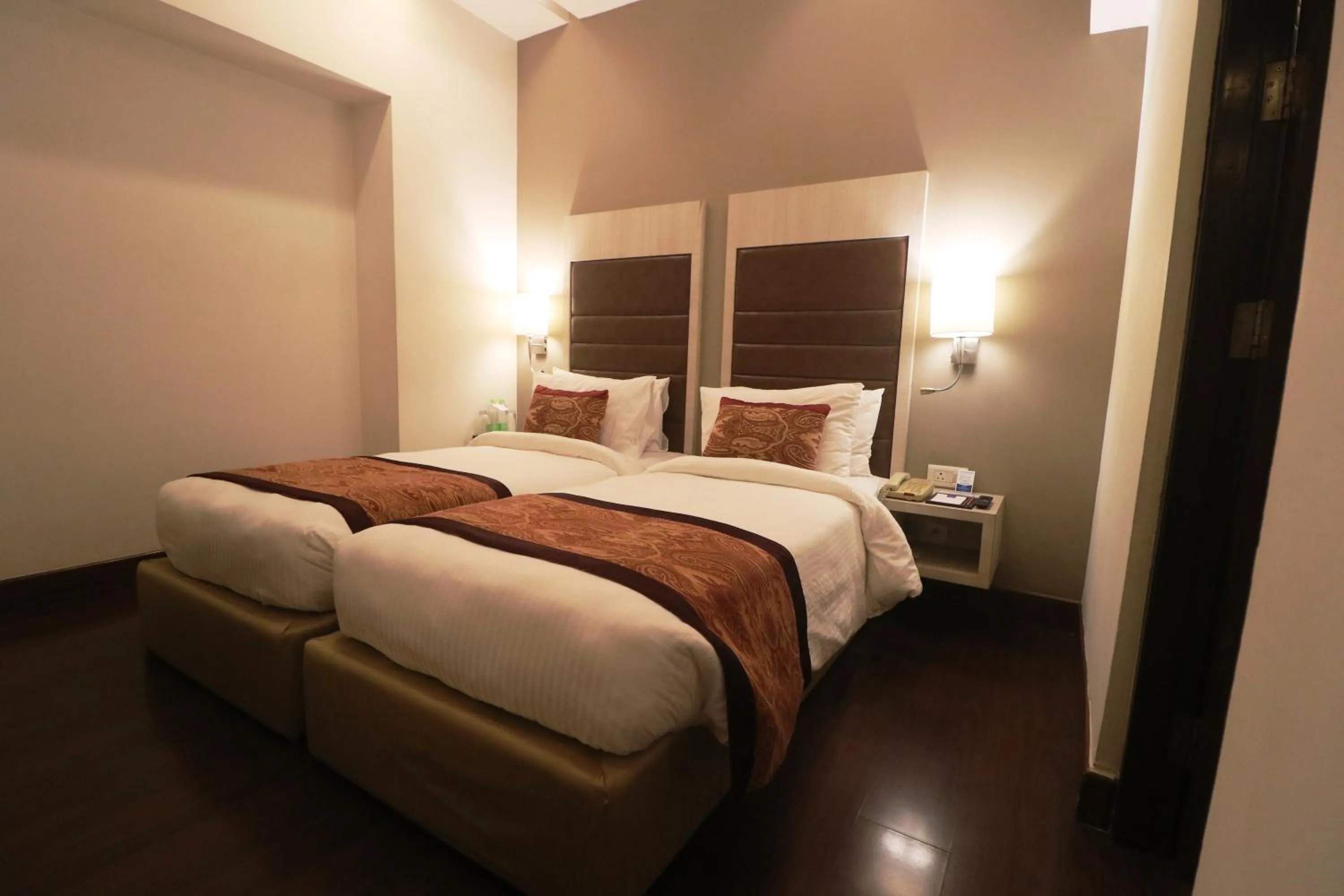 Bed in Mahagun Sarovar Portico Suites
