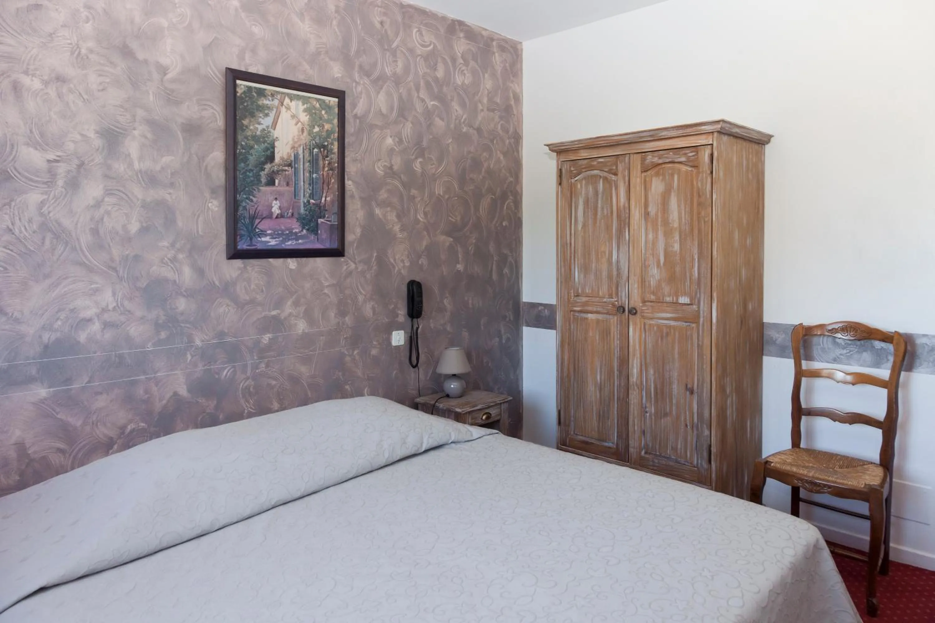 Bed in Logis Hotel du Midi