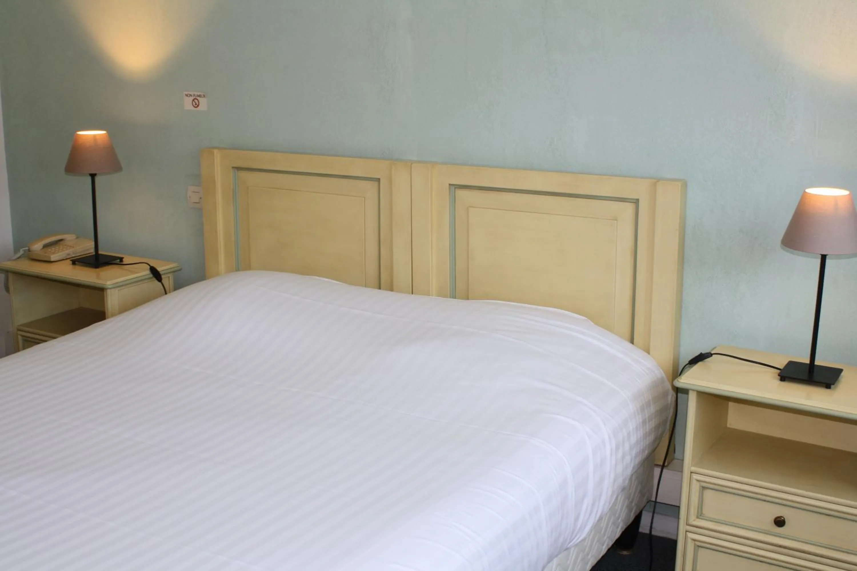 Bed in Logis Hotel du Midi