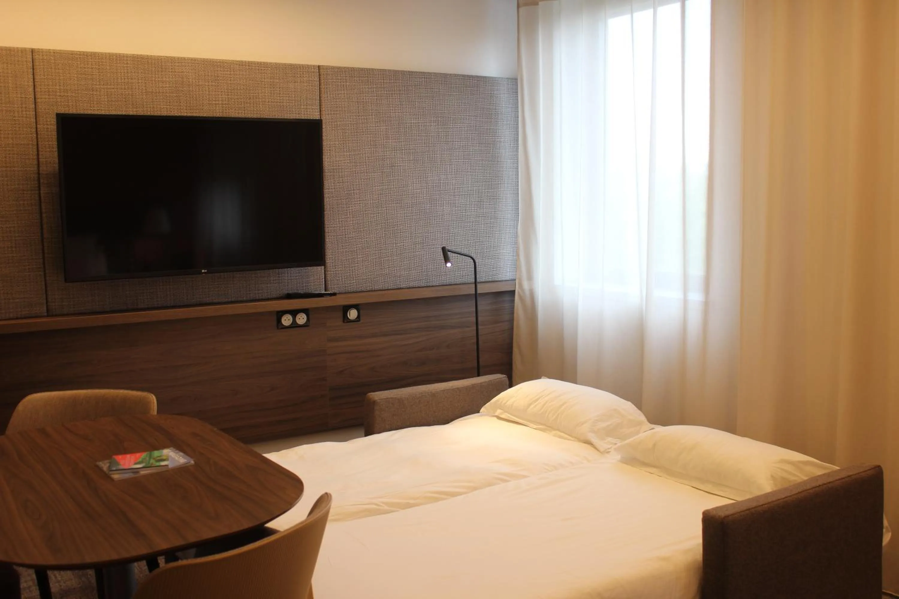 Communal lounge/ TV room, Bed in Novotel Suites Rouen Normandie