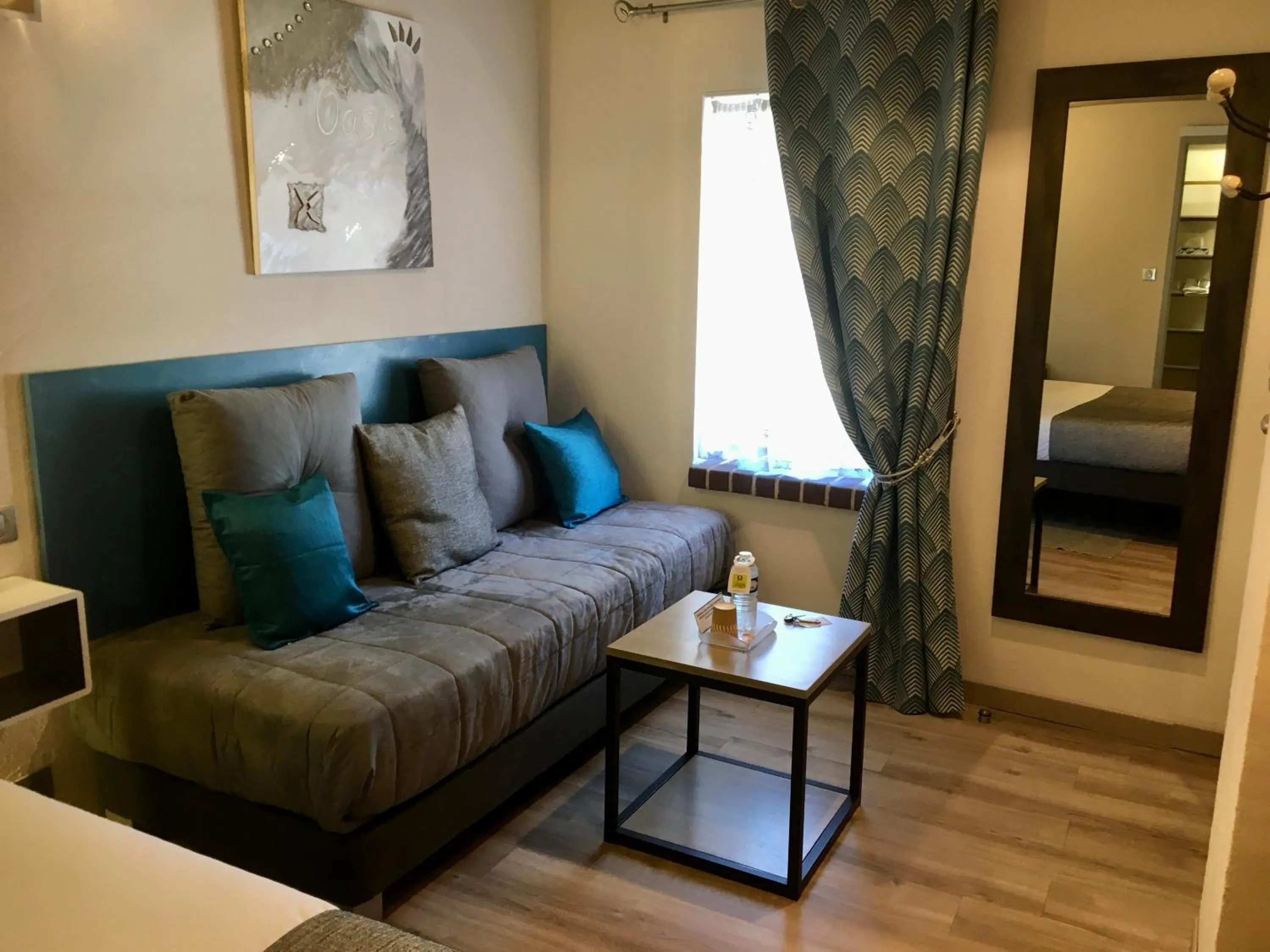 Communal lounge/ TV room, Bed in Logis Hotel Oasis