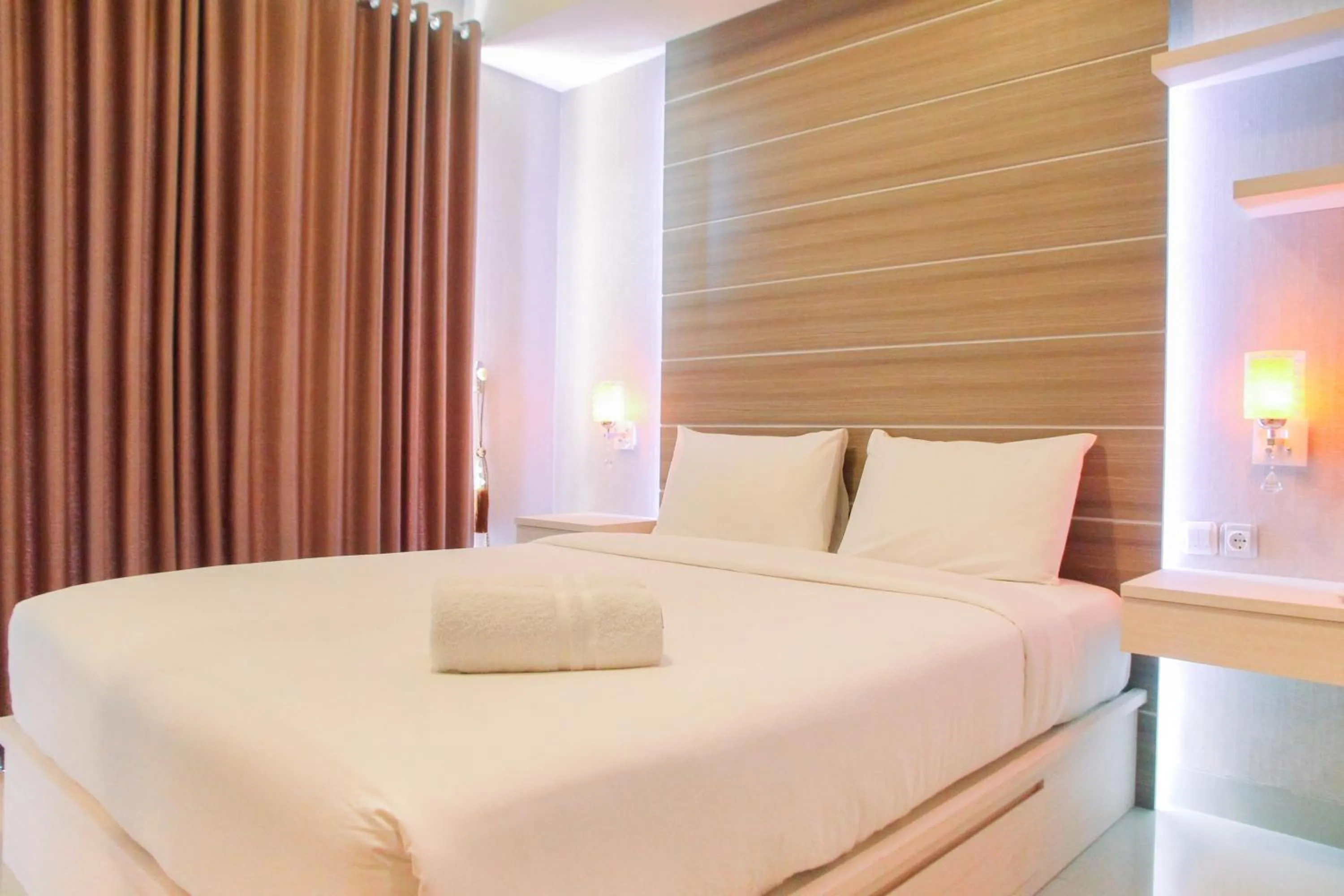 Bed in Best Price 1BR Apartment at The Oasis Cikarang By Travelio