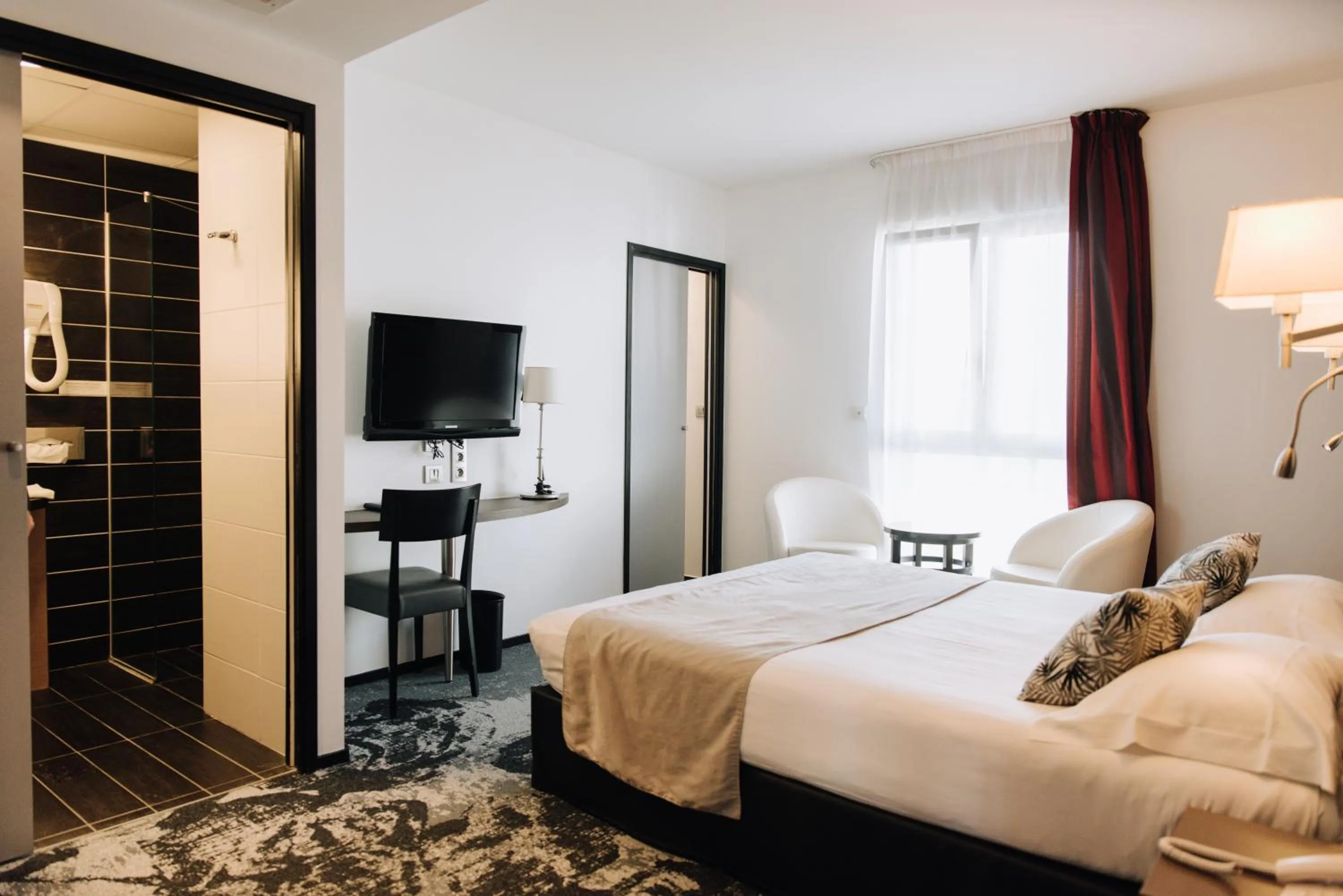 Bed in Logis Hôtel Victor Hugo & Spa