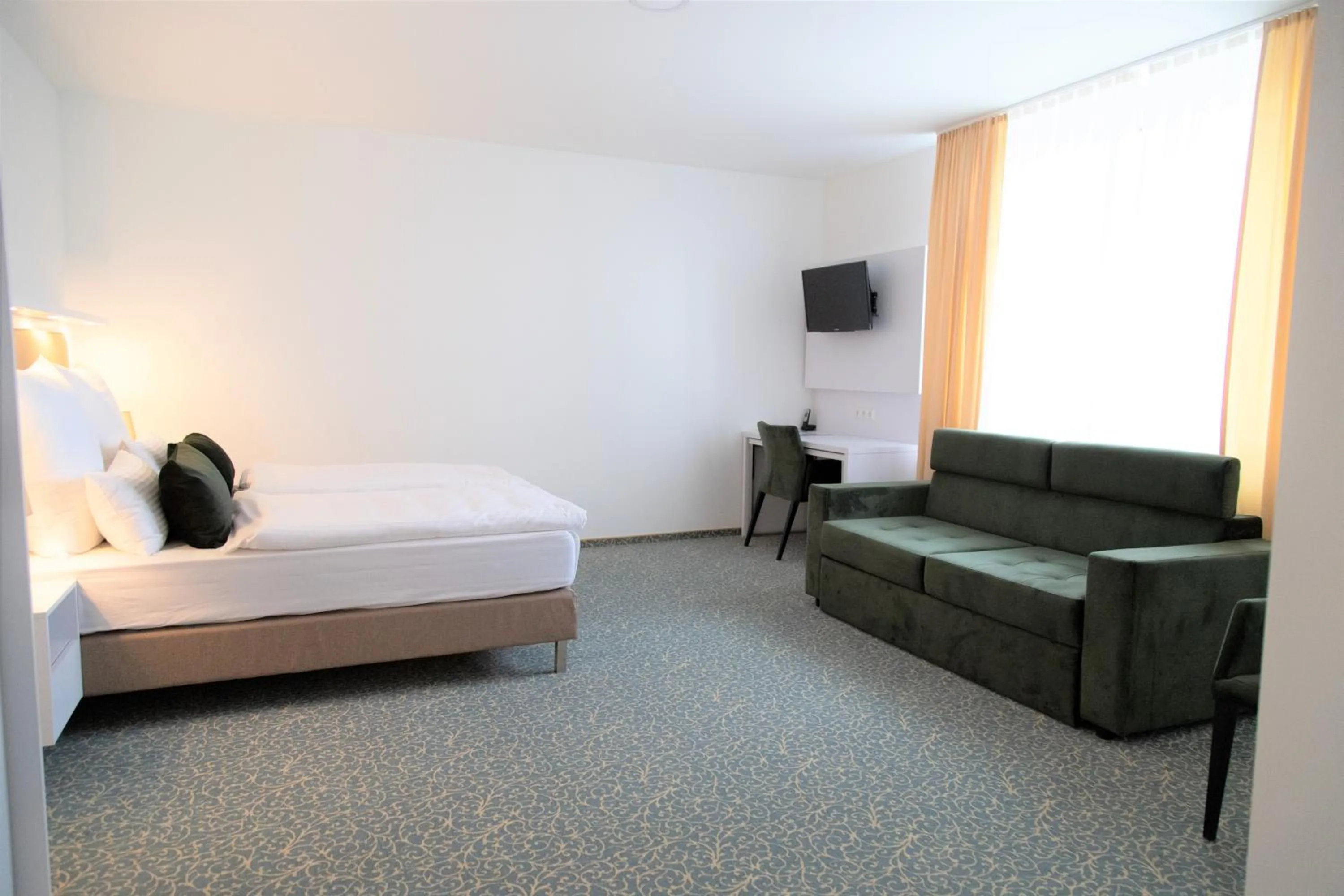 Living room, Bed in Amplidi Hotel Hannover