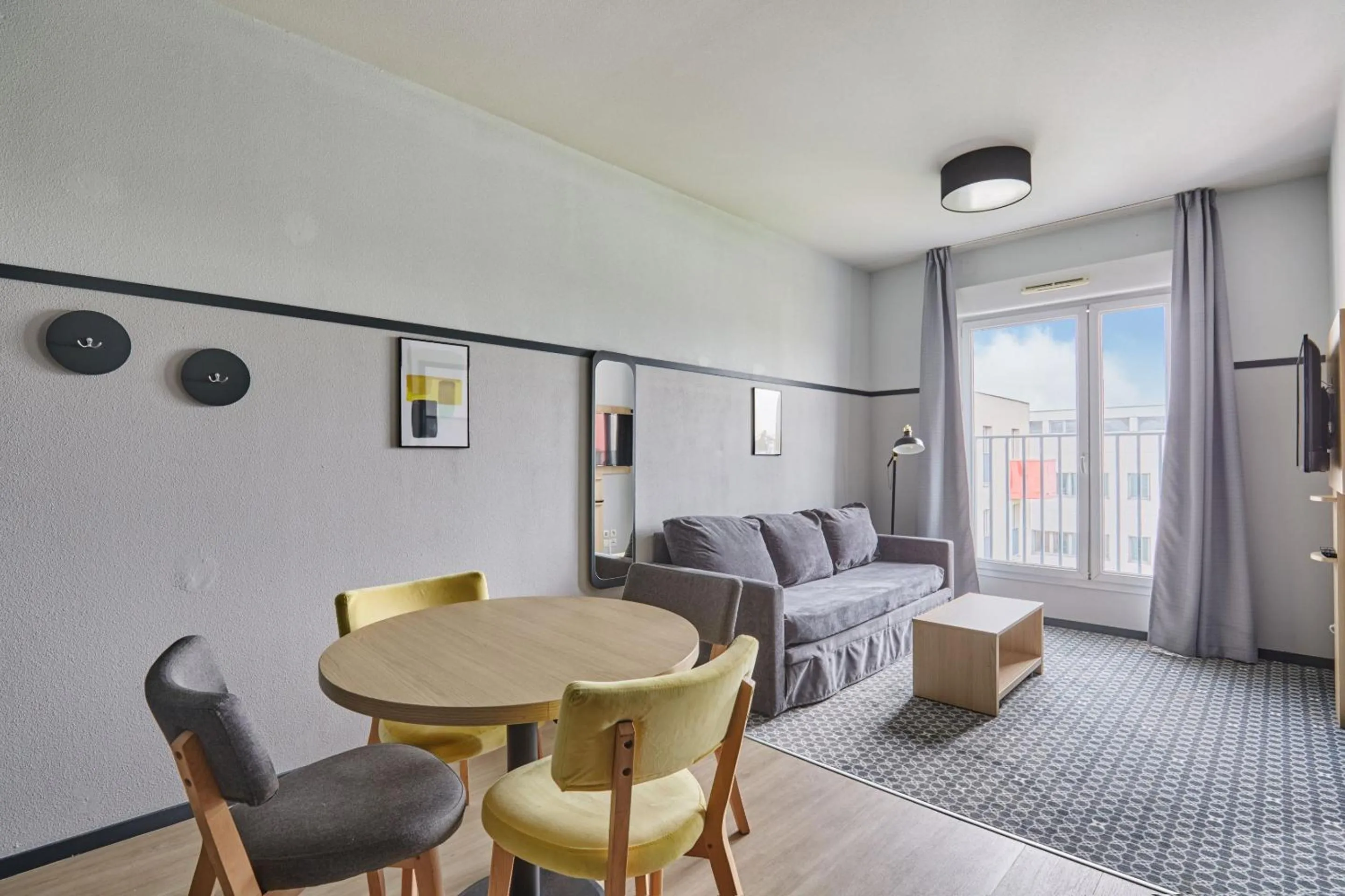 Living room, Bed in Appart'hôtel Odalys City - Bioparc Lyon Est