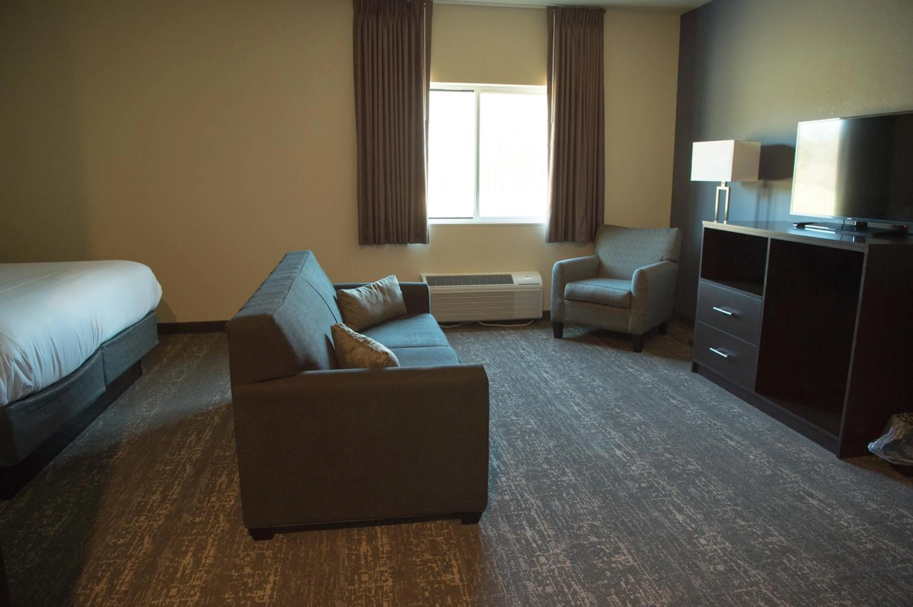 Seating area, Bed in Cobblestone Inn & Suites - Forest City