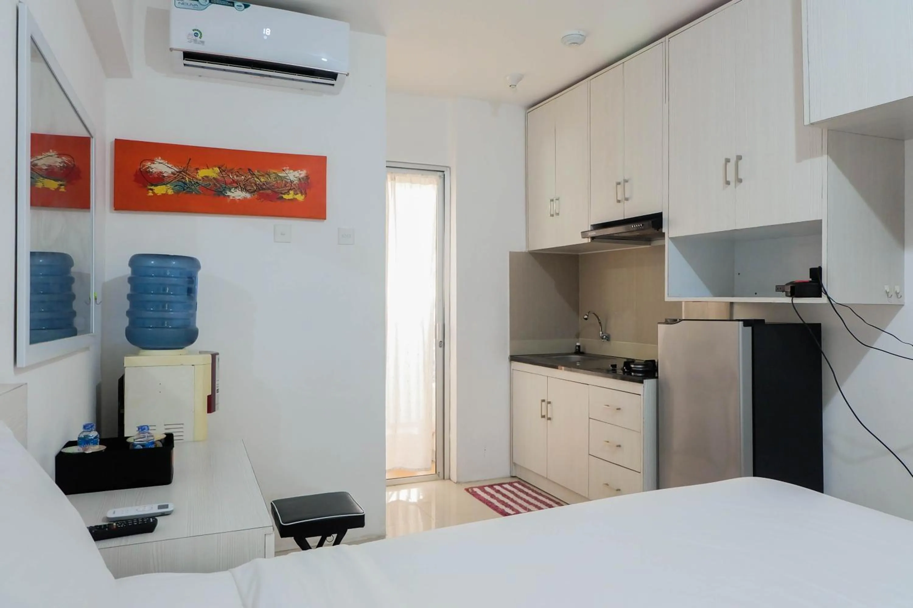 Kitchen or kitchenette, Bed in Tidy Studio Apartment at Bassura City near Shopping Mall By Travelio