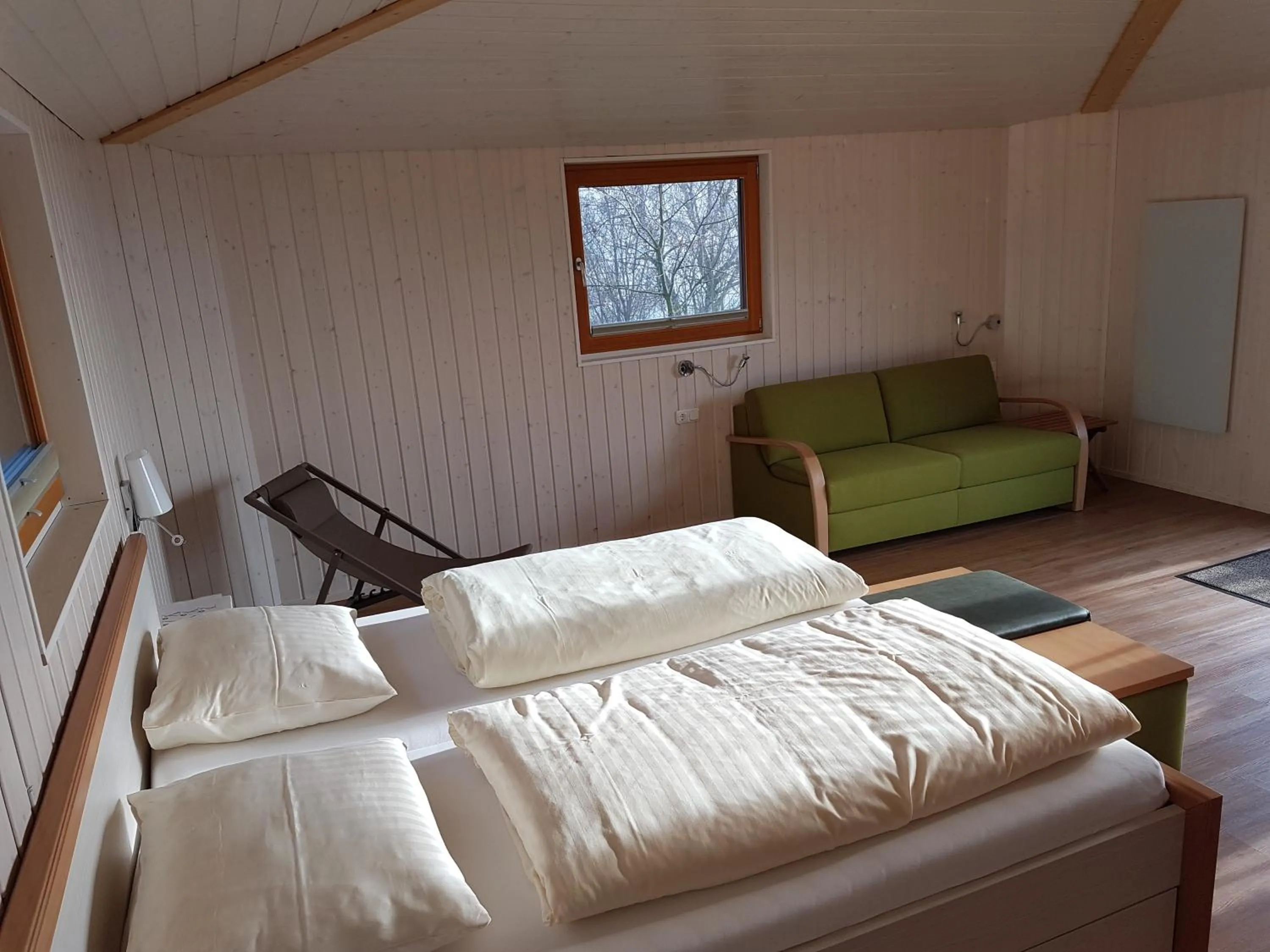 Seating area, Bed in Hotel Waldquelle - Baumhaushotel Aerzen