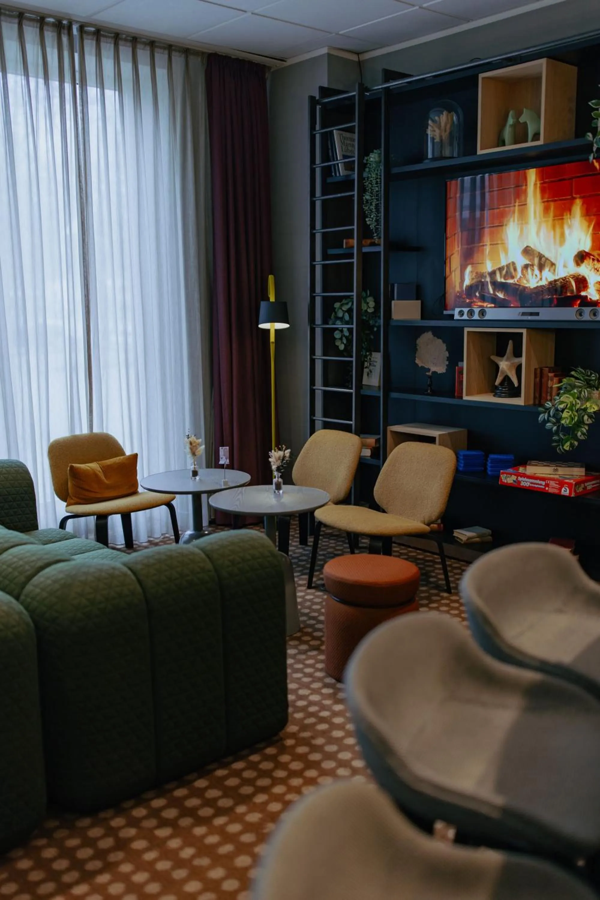 Communal lounge/ TV room in Holiday Inn Lübeck by IHG
