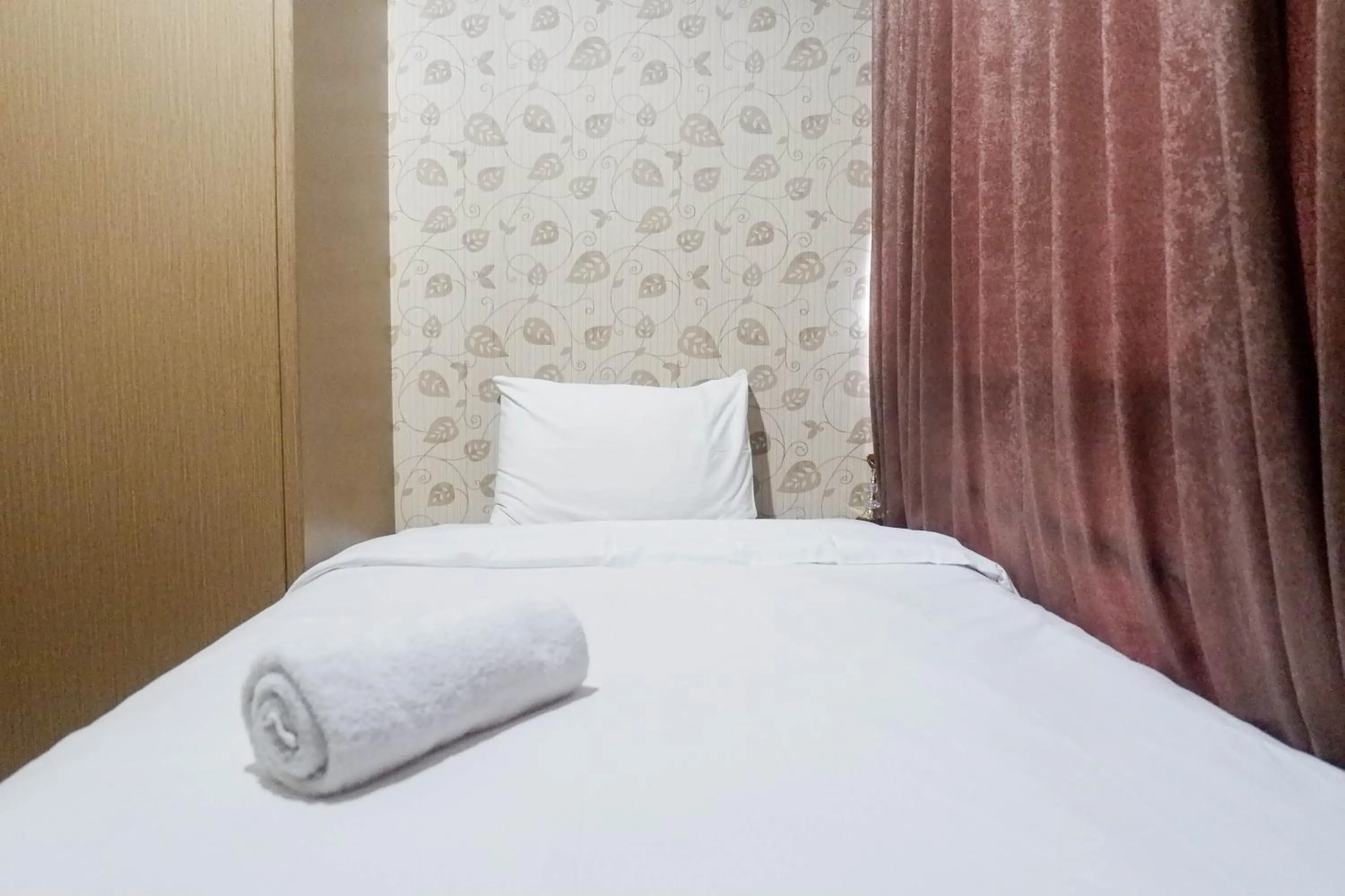 Bed in Minimalist 2BR Apartment at Tamansari Papilio By Travelio