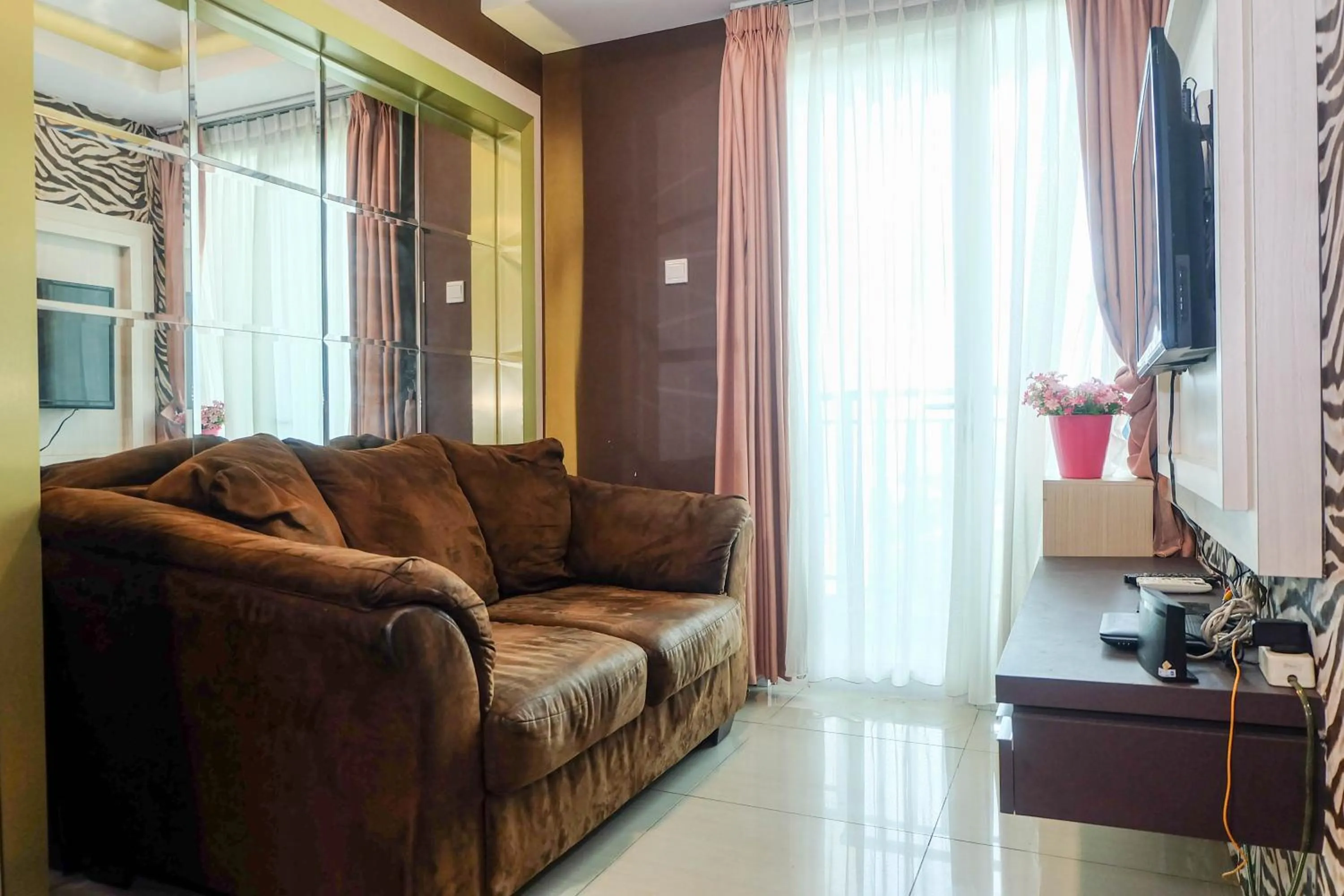 Living room in Good Location with Simply Furnished 1BR Apartment Woodland Park Residence By Travelio