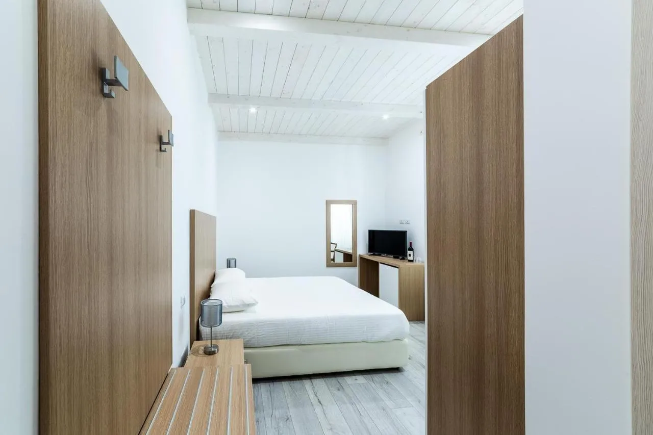 Bed in La Promenade Rooms & Suites