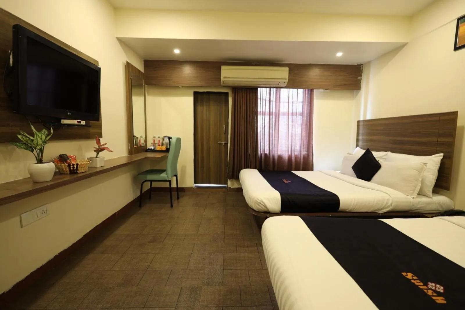 Communal lounge/ TV room, Bed in Saish Hotel Shirdi