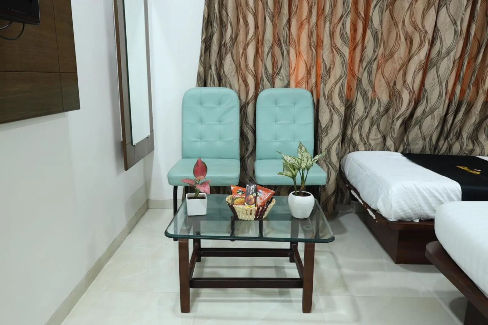 Seating area, Bed in Saish Hotel Shirdi