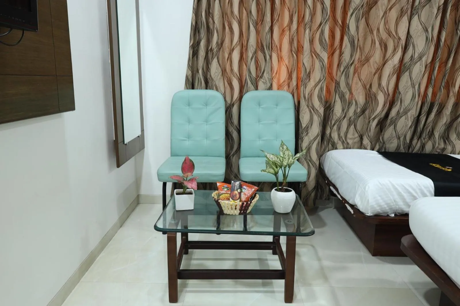 Seating area, Bed in Saish Hotel Shirdi
