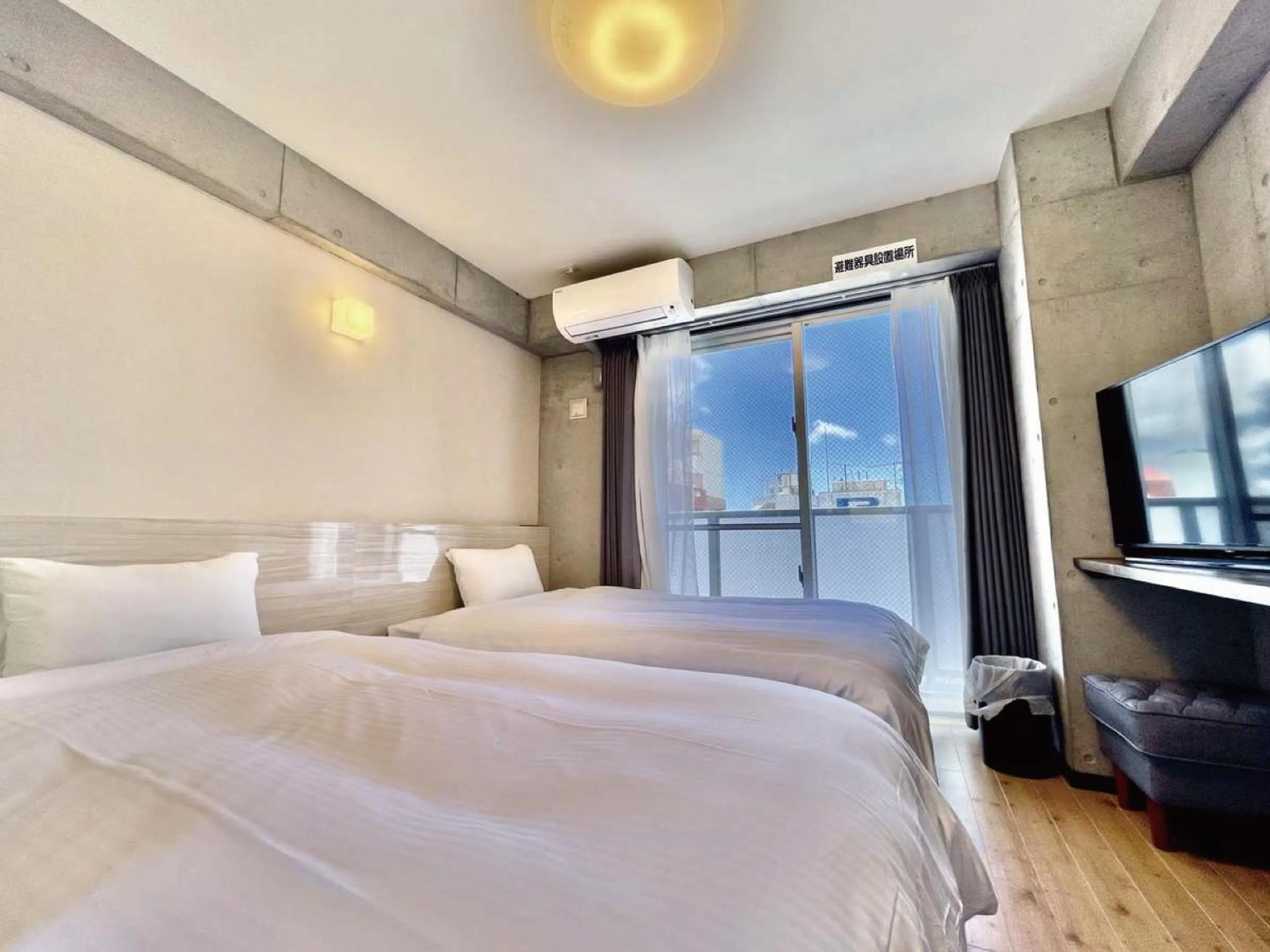 Bed in Infinity Hotel NahaKumoji -SEVEN Hotels and Resorts-