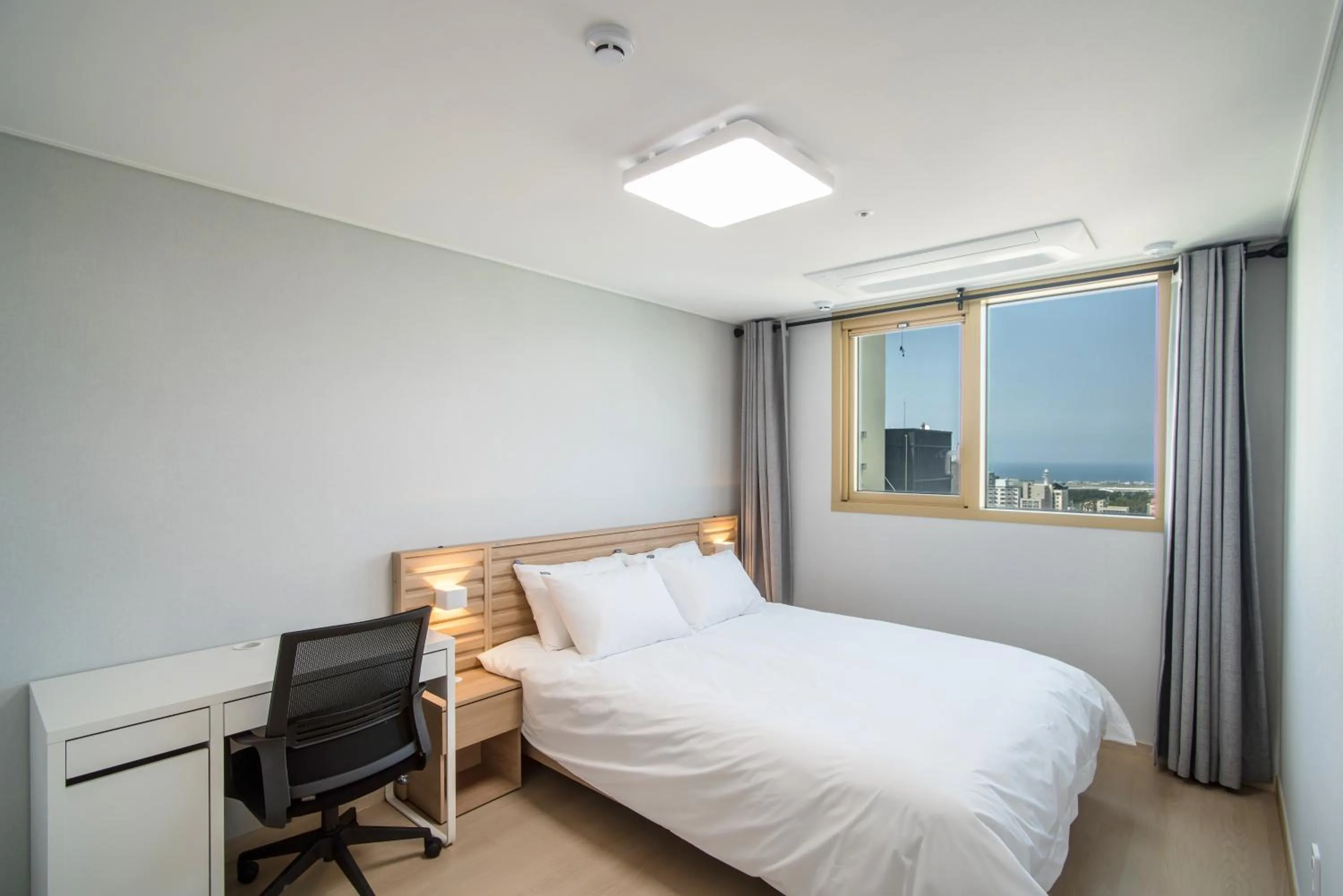Seating area, Bed in Jeju Central Park Residence