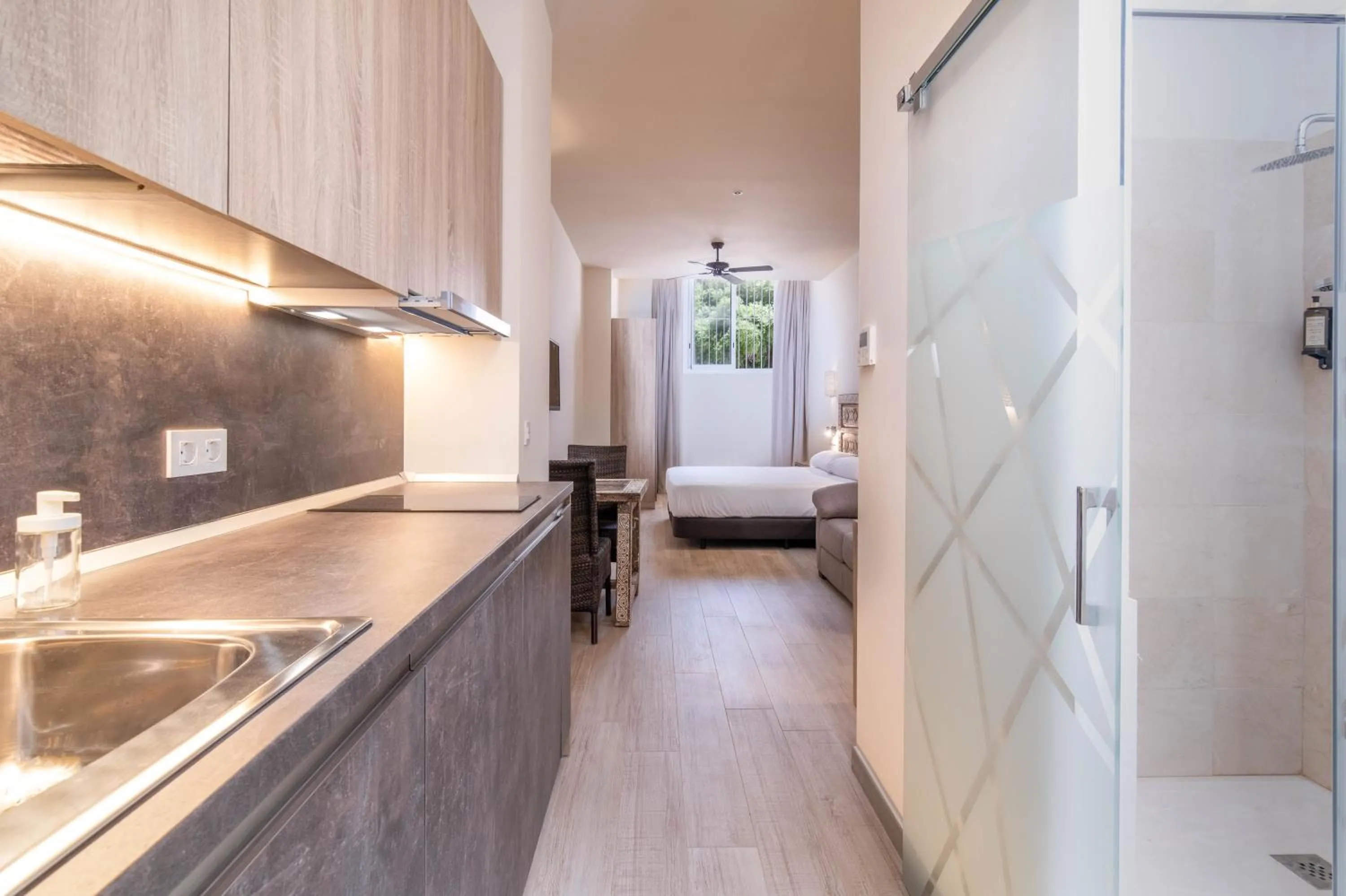 Kitchen or kitchenette, Bed in Tarifa Suites by QHotels