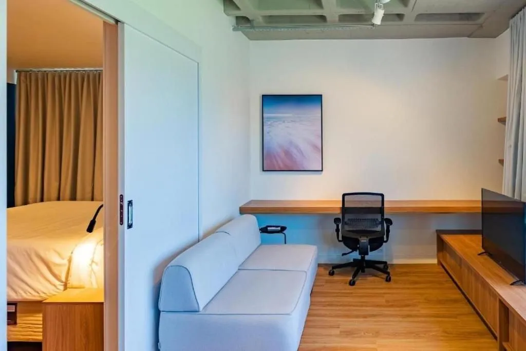 Living room, Bed in Atrium Studios by Xtay - Conforto em Palhoça, a poucos metros da praia