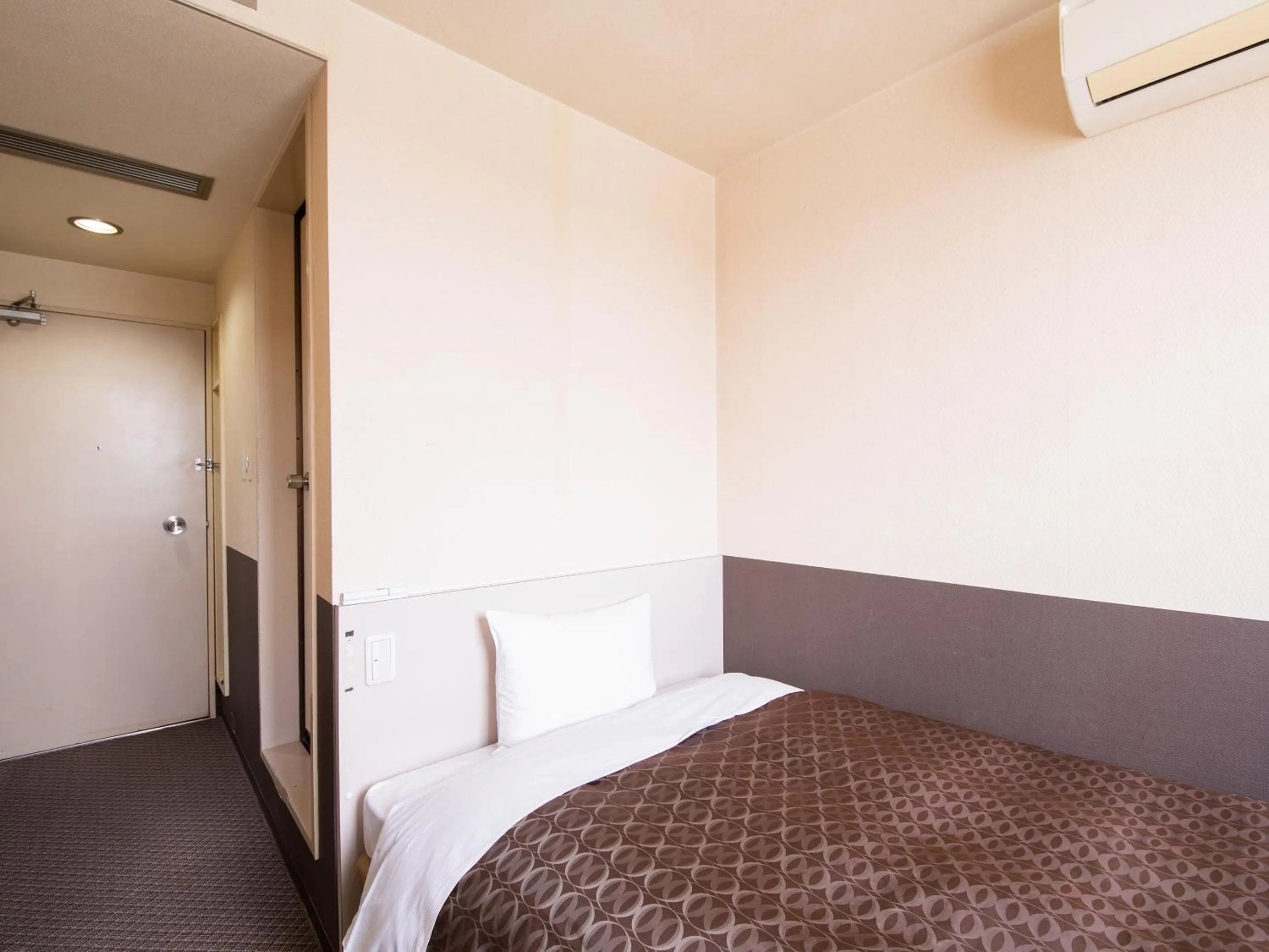 Bed in Hotel Primrose Saito