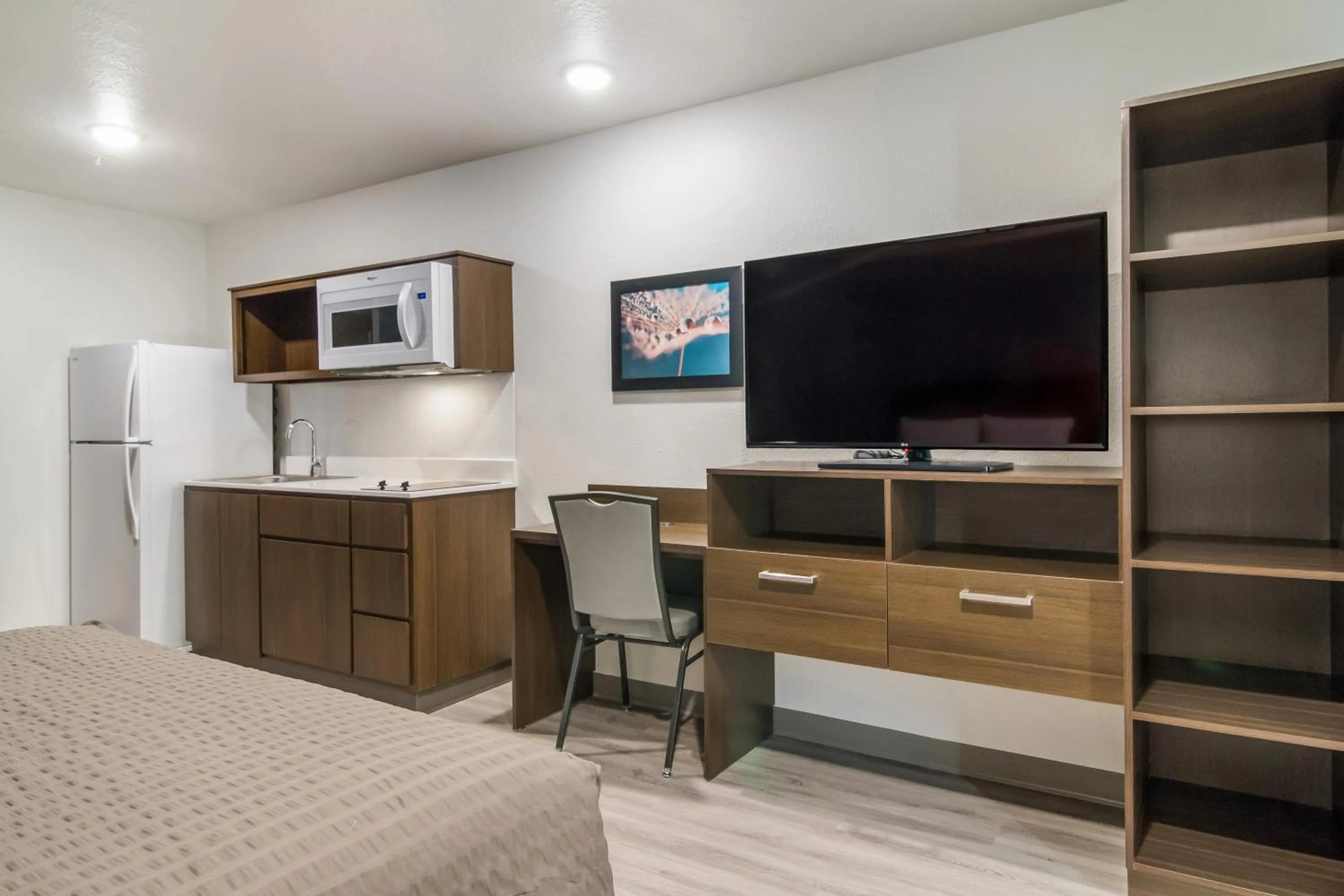 Communal lounge/ TV room, Bed in WoodSpring Suites Greensboro - High Point North