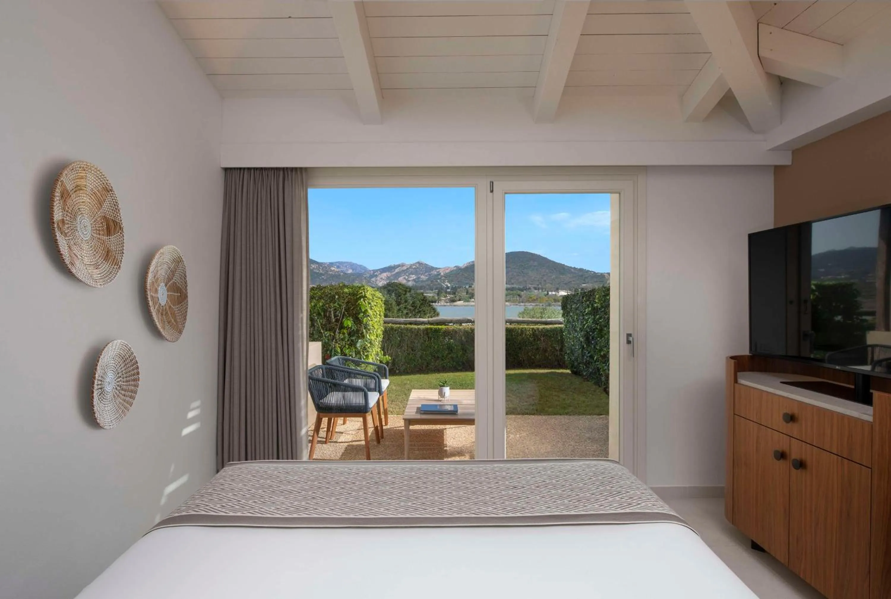 Living room, Bed in Baia Di Chia Resort Sardinia, Curio Collection By Hilton
