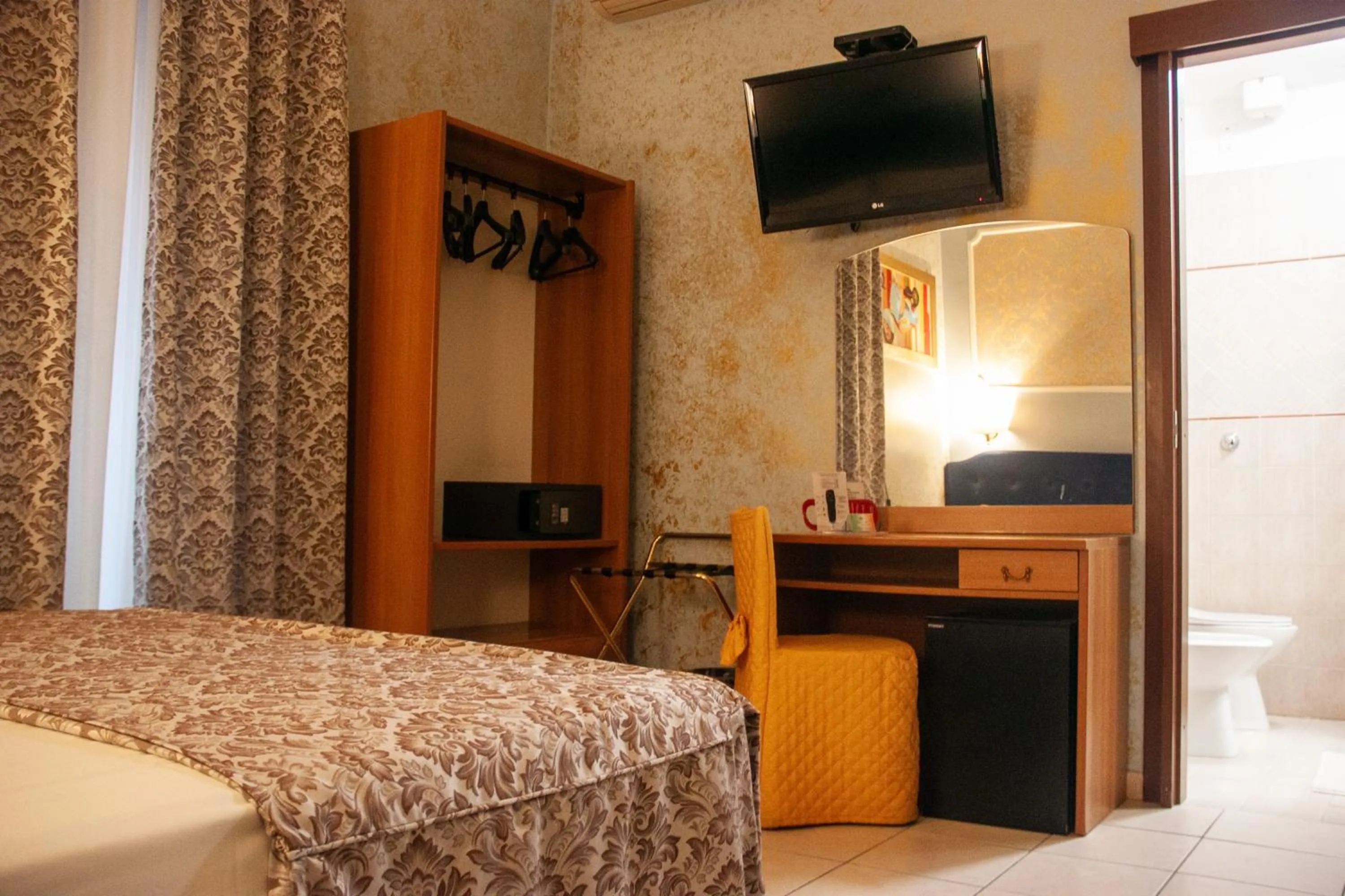 Communal lounge/ TV room, Bed in Hotel Assisi
